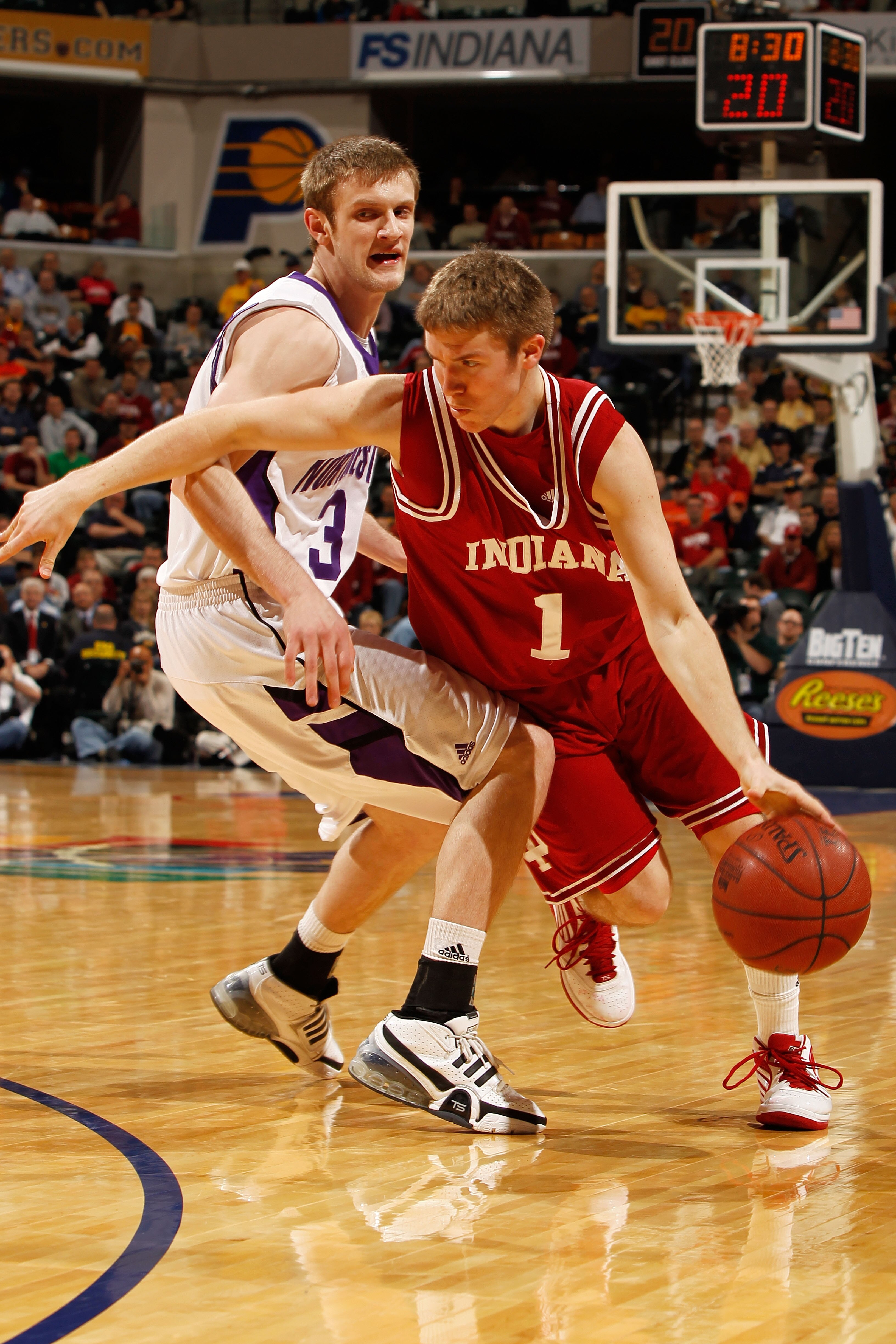 INDIANAPOLIS - MARCH 11:  Guard Jordan Hulls #1 of the Indiana Hoosiers drives with the ball against forward Mike Capocci #3 of the Northwestern Wildcats during the first round of the Big Ten Men's Basketball Tournament at Conseco Fieldhouse on March 11,