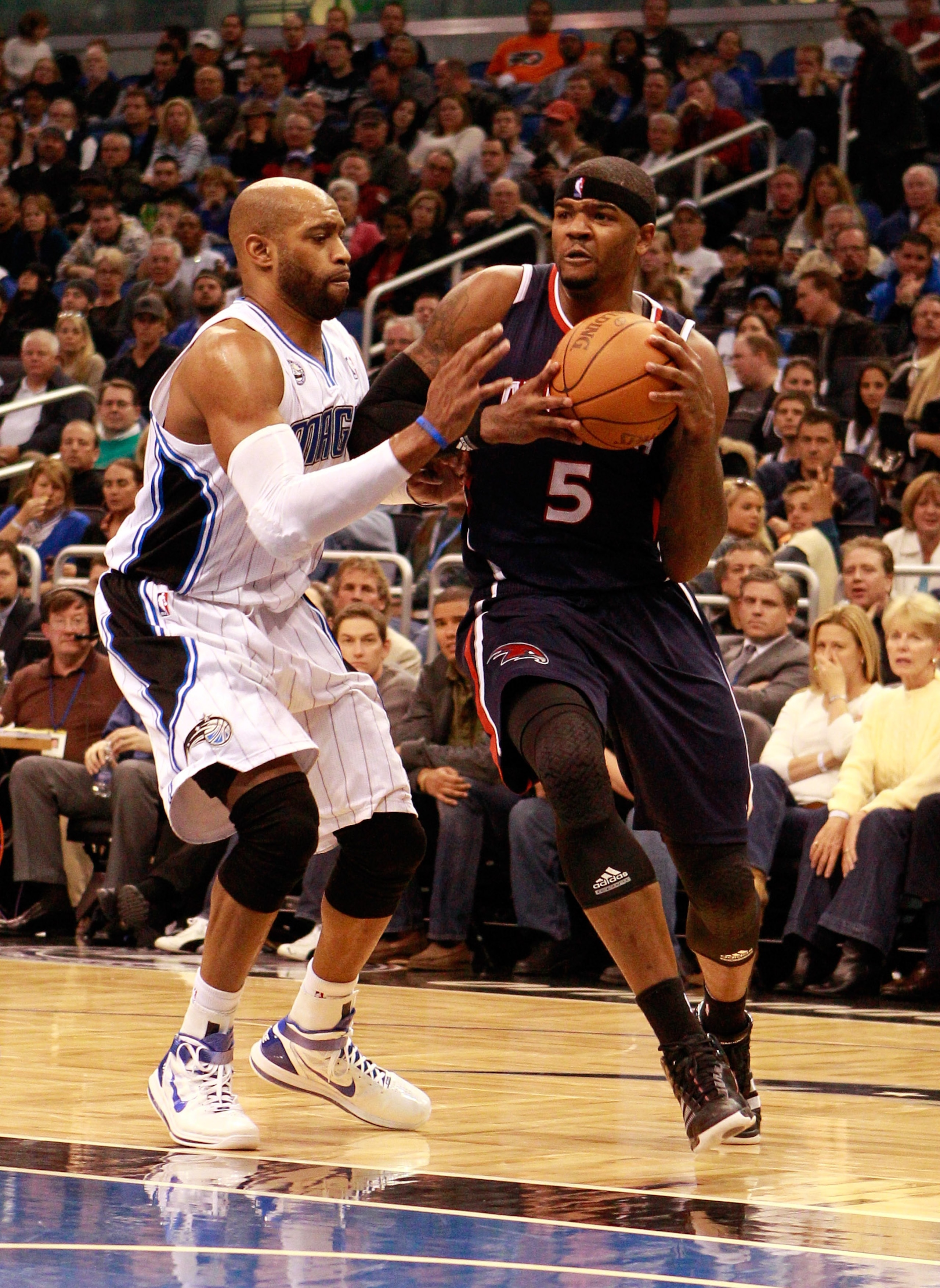 ORLANDO, FL - DECEMBER 06:  Josh Smith #5 of the Atlanta Hawks drives against Vince Carter#15 of the Orlando Magic during the game at Amway Arena on December 6, 2010 in Orlando, Florida. NOTE TO USER: User expressly acknowledges and agrees that, by downlo