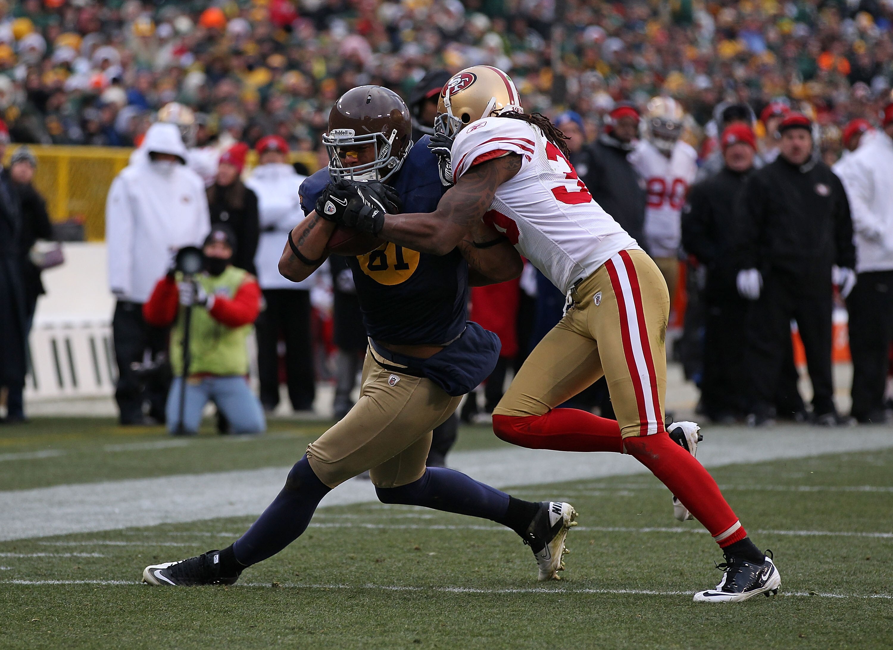 GREEN BAY, WI - DECEMBER 05: Dashon Goldson #38 of the San Francisco 49ers tackles Andrew Quarless #81 of the Green Bay Packers at Lambeau Field on December 5, 2010 in Green Bay, Wisconsin. The Packers defeated the 49ers 34-16. (Photo by Jonathan Daniel/G