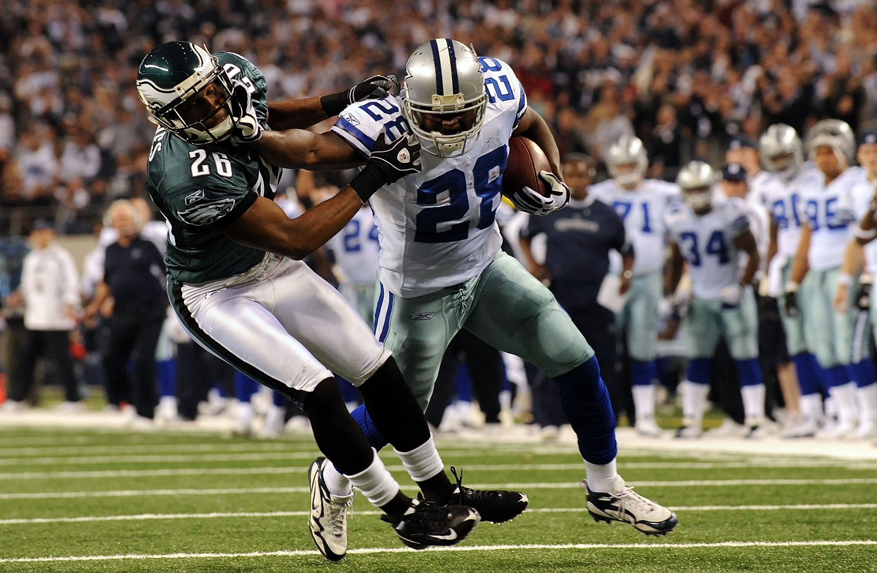 ARLINGTON, TX - JANUARY 09:  Running back Felix Jones #28 of the Dallas Cowboys runs the ball past Sean Jones #26 of the Philadelphia Eagles during the 2010 NFC wild-card playoff game at Cowboys Stadium on January 9, 2010 in Arlington, Texas.  (Photo by R