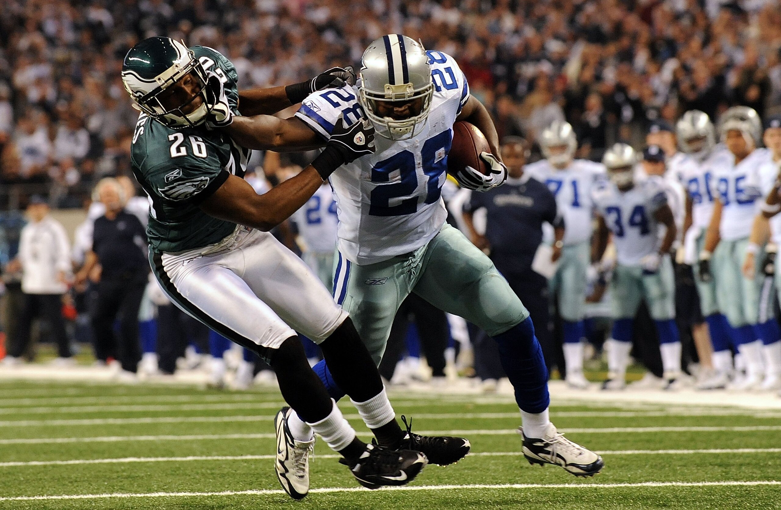 ARLINGTON, TX - JANUARY 09:  Running back Felix Jones #28 of the Dallas Cowboys runs the ball past Sean Jones #26 of the Philadelphia Eagles during the 2010 NFC wild-card playoff game at Cowboys Stadium on January 9, 2010 in Arlington, Texas.  (Photo by R