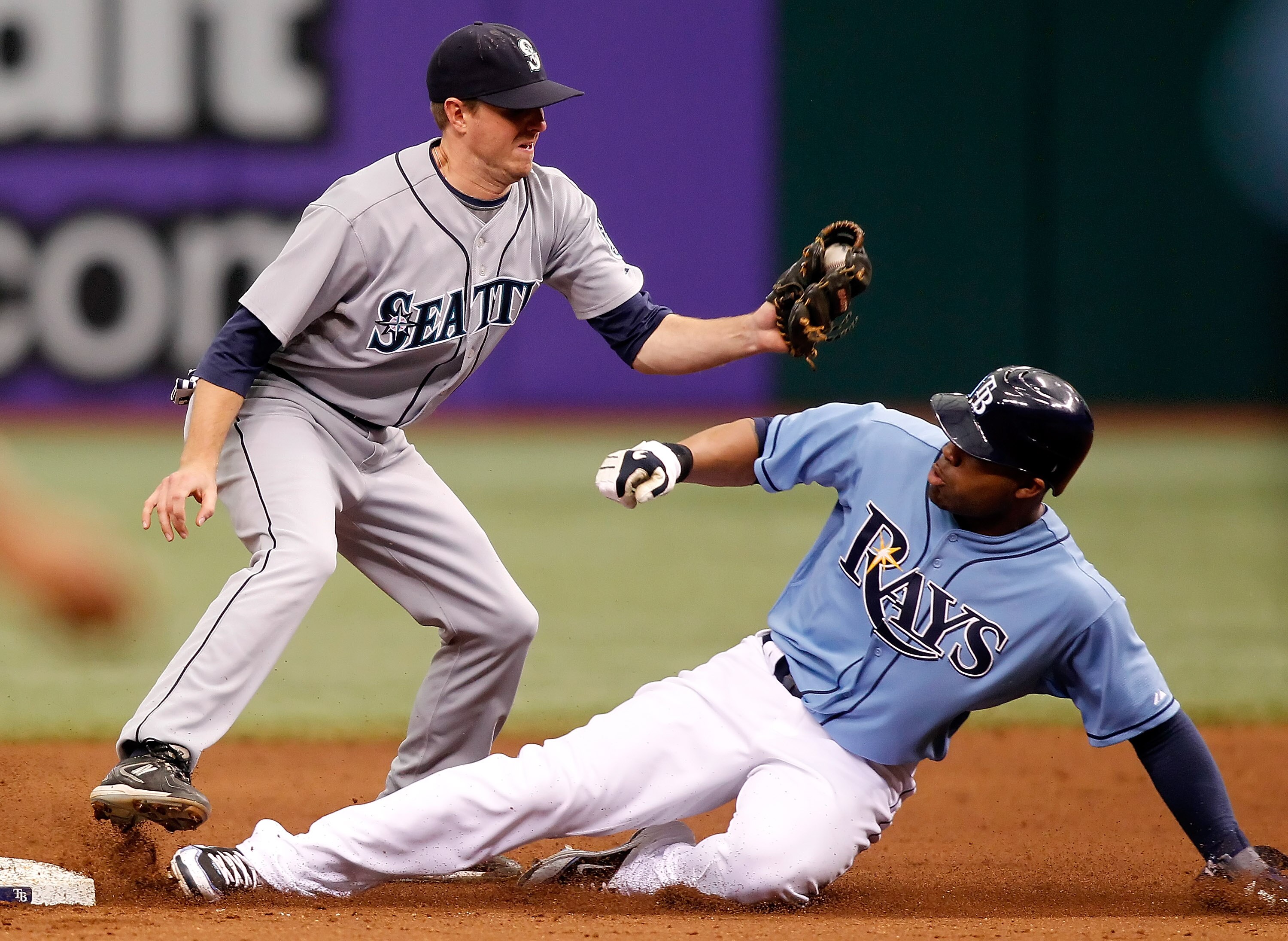 ST. PETERSBURG - MAY 16:  Outfielder Carl Crawford #13 of the Tampa Bay Rays steals second base as shortstop Josh Wilson #16 of the Seattle Mariners takes the throw during the game at Tropicana Field on May 16, 2010 in St. Petersburg, Florida.  (Photo by