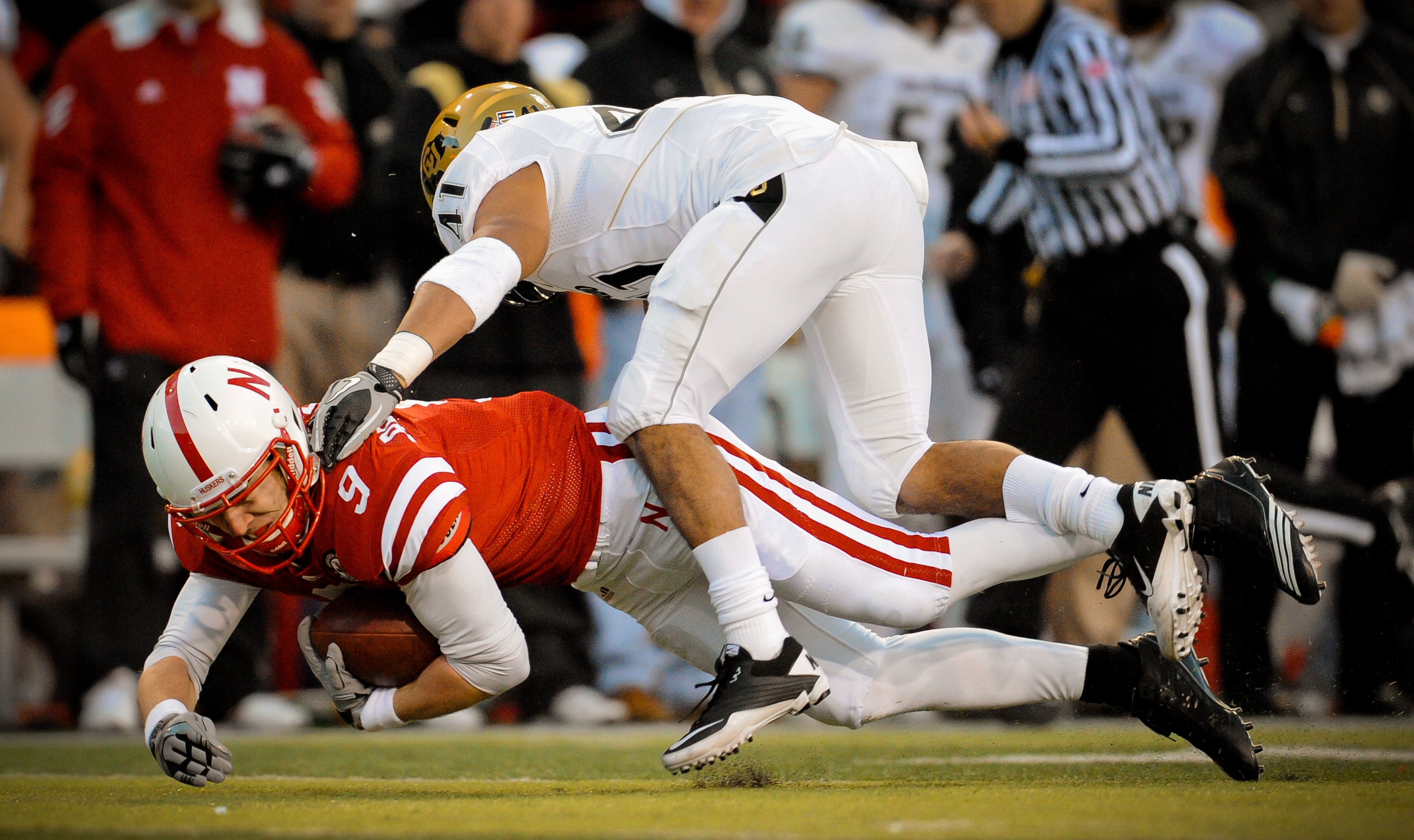 LINCOLN, NE - NOVEMBER 26: Joe Broekemeier #9 of the Nebraska Cornhuskers is brought down by Terrel Smith #41 of the Colorado Buffaloes during the second half of their game at Memorial Stadium on November 26, 2010 in Lincoln, Nebraska. Nebraska defeated C