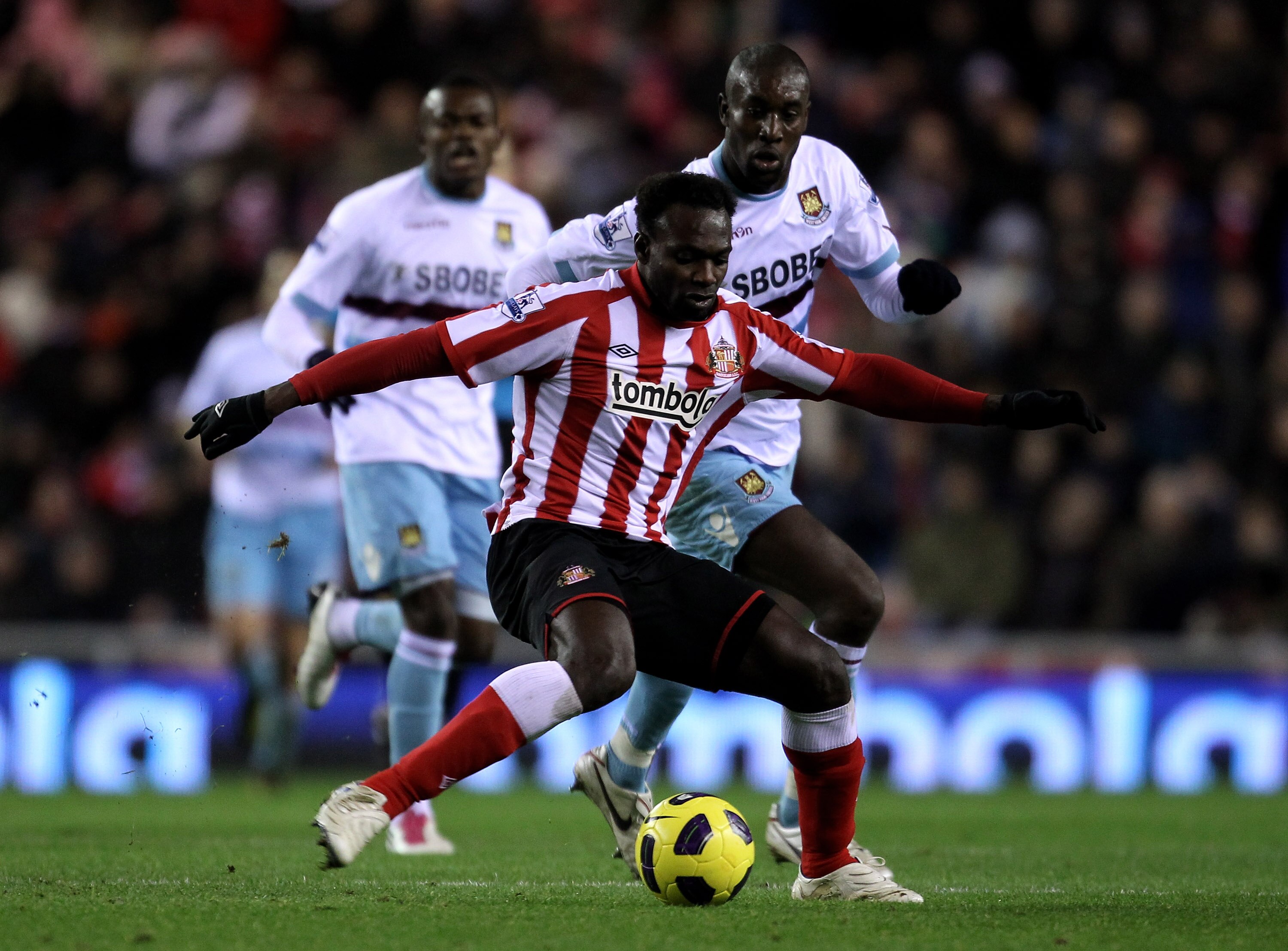 SUNDERLAND, ENGLAND - DECEMBER 05:  John Mensah of Sunderland competes with Carlton Cole of West Ham United during the Barclays Premier League match between Sunderland and West Ham United at the Stadium of Light on December 5, 2010 in Sunderland, England.
