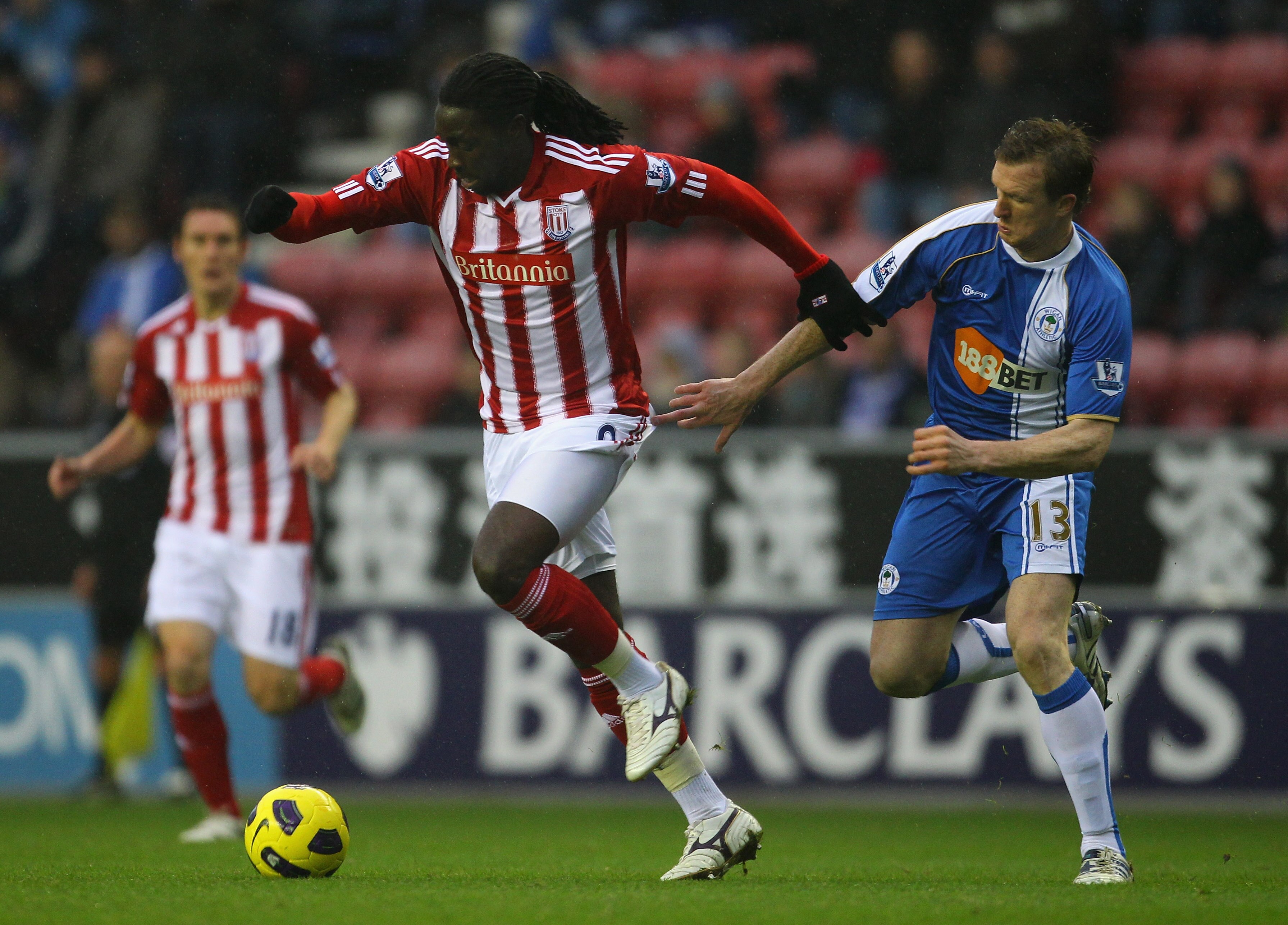 WIGAN, ENGLAND - DECEMBER 04:  Kenwyne Jones of Stoke City holds off a challenge from Steven Caldwell of Wigan Athletic during the Barclays Premier League match between Wigan Athletic and Stoke City at DW Stadium on December 4, 2010 in Wigan, England.  (P