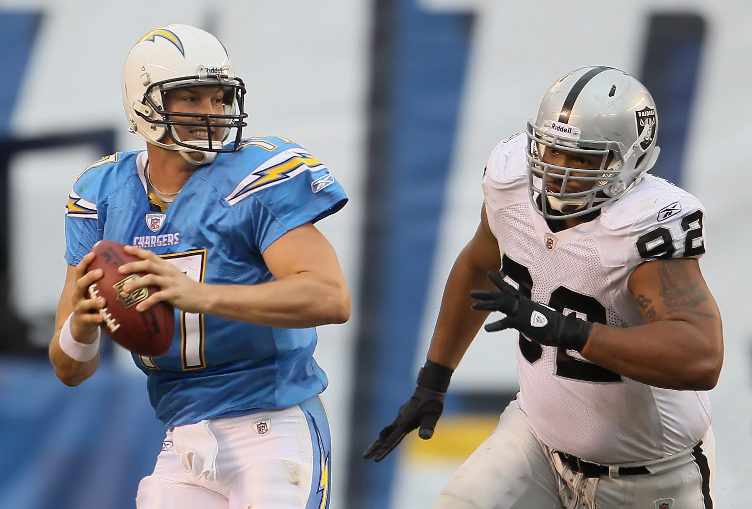 SAN DIEGO - DECEMBER 05:  Quarterback Philip Rivers #17 of the San Diego Chargers is chased out of the pocket by Richard Seymour #92 of the Oakland Raiders in the third quarter at Qualcomm Stadium on December 5, 2010 in San Diego, California. The Raiders 