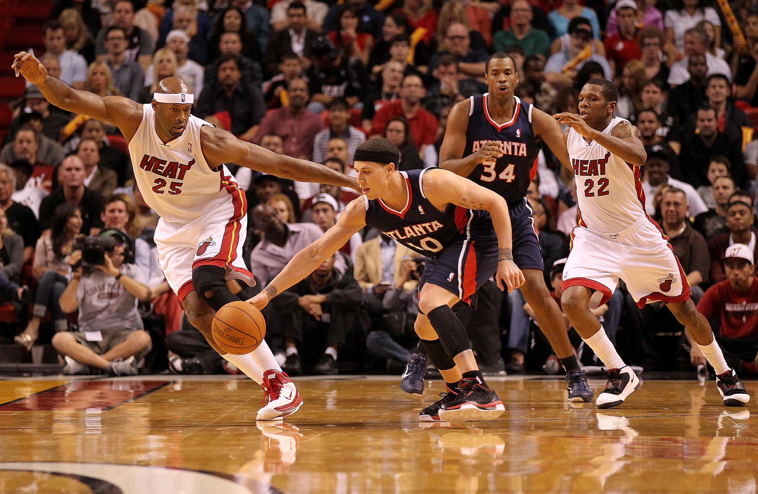 MIAMI, FL - DECEMBER 04: Mike Bibby #10 of the Atlanta Hawks fights for a loose ball against Eric Dampier #25 of the Miami Heat during a game at American Airlines Arena on December 4, 2010 in Miami, Florida. NOTE TO USER: User expressly acknowledges and a