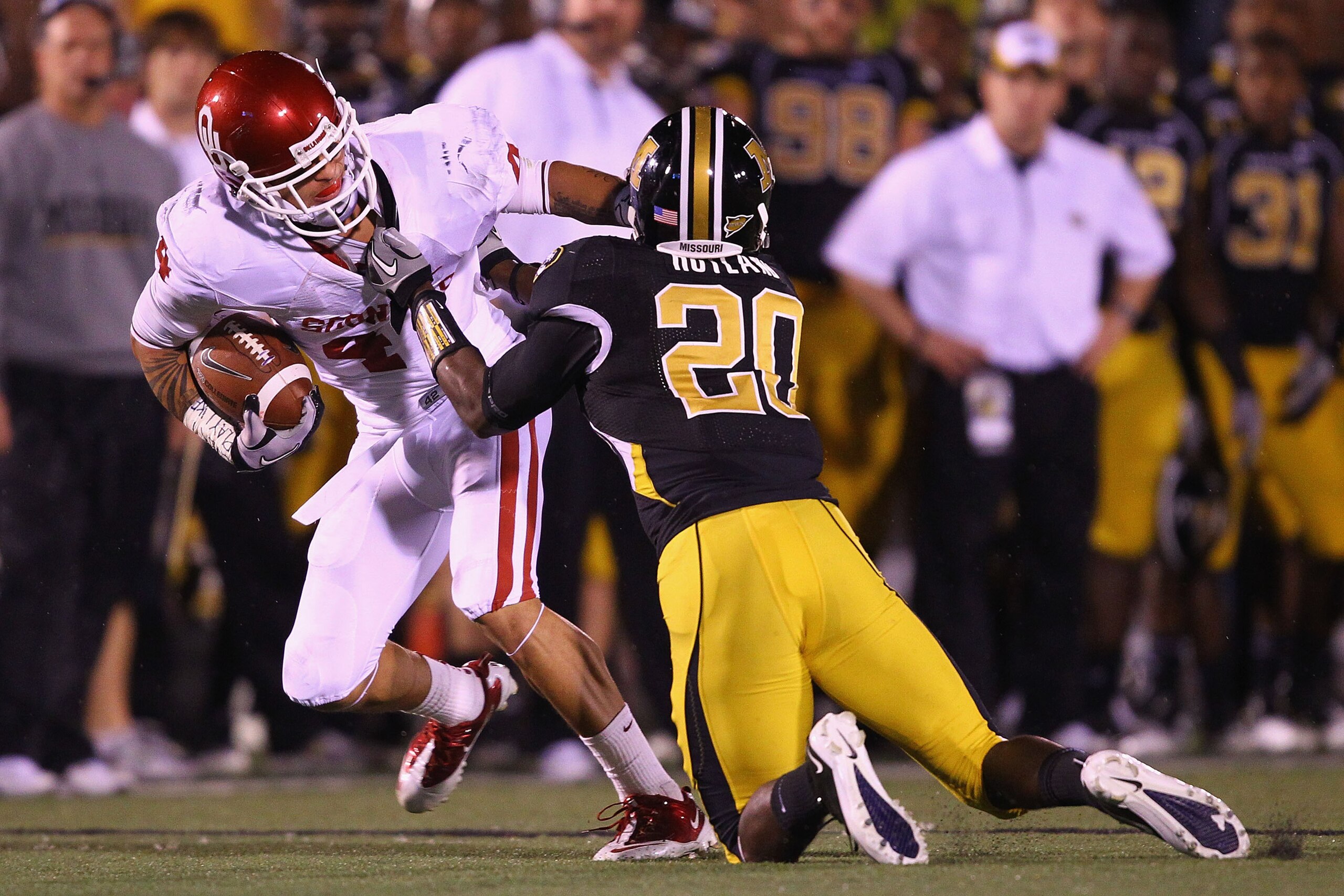 COLUMBIA, MISSOURI - OCTOBER 23: Kenny Stills #4 of the Oklahoma Sooners is tackled by Kevin Rutland #20 of the Missouri Tigers at Faurot Field/Memorial Stadium on October 23, 2010 in Columbia, Missouri.  The Tigers beat the Sooners 36-27.  (Photo by Dili