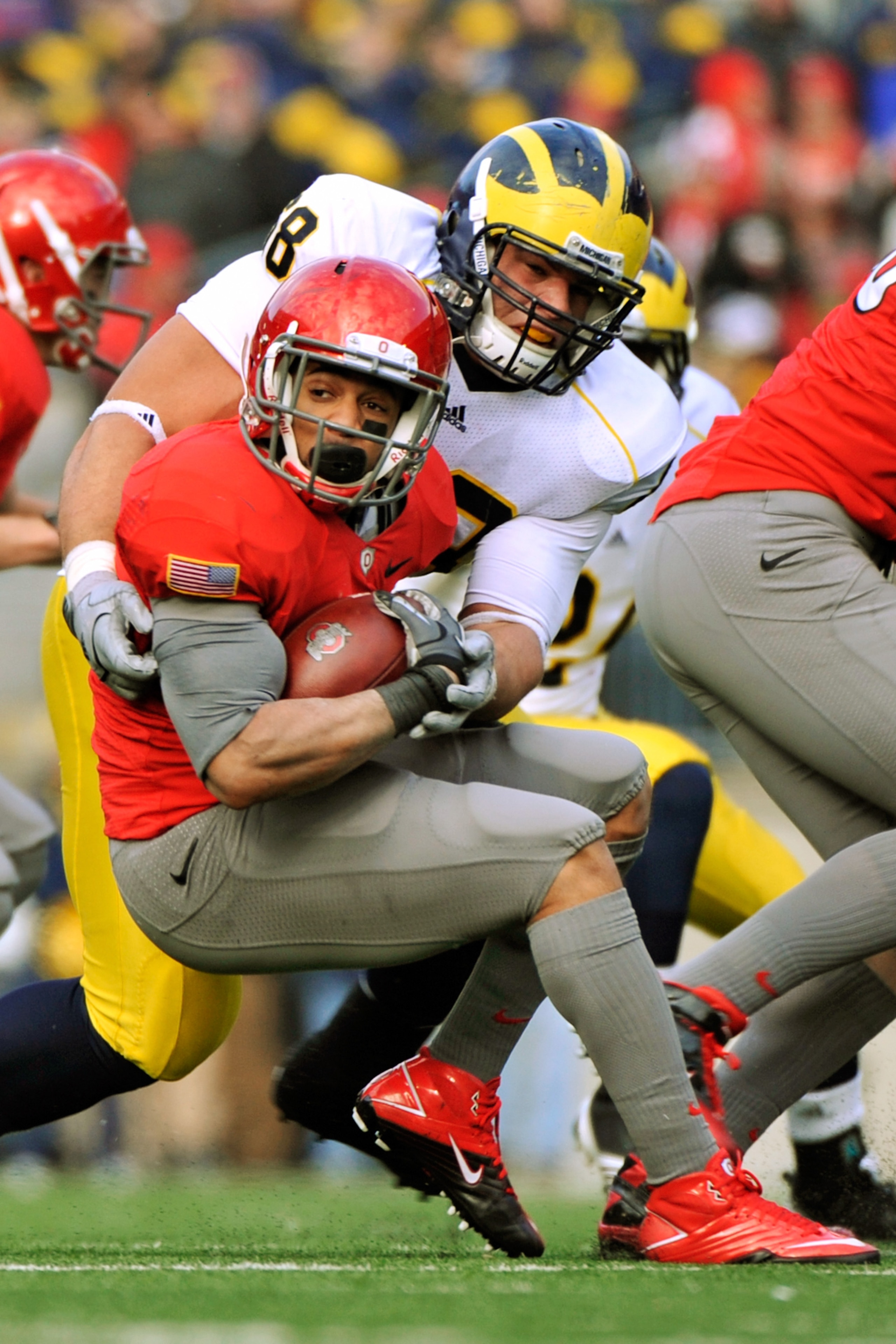 COLUMBUS, OH - NOVEMBER 27:  Running back Dan Herron #1 of the Ohio State Buckeyes is wrapped up by Mike Martin #68 of the Michigan Wolverines at Ohio Stadium on November 27, 2010 in Columbus, Ohio. Herron rushed for 175 yards and one touchdown as Ohio St