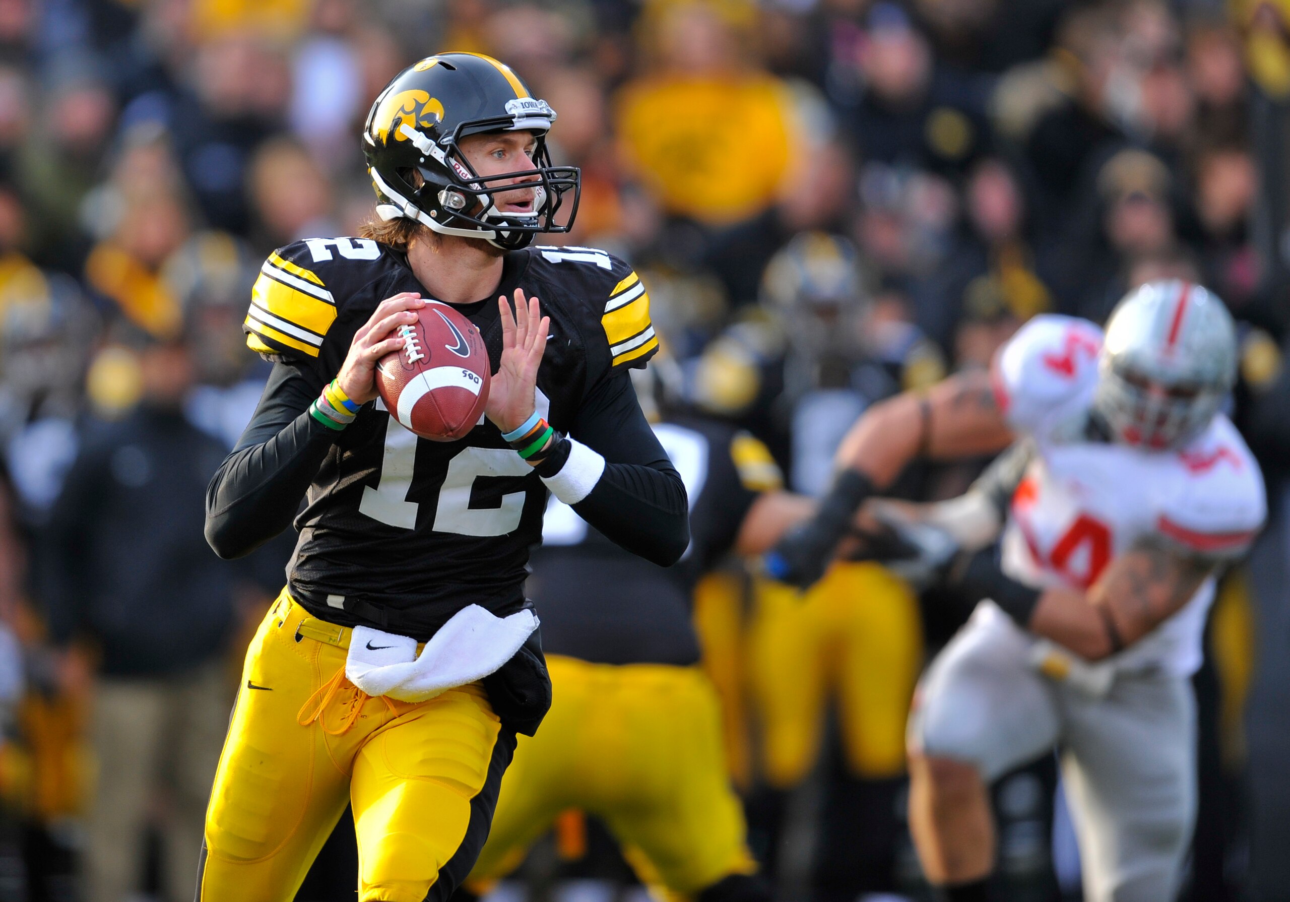IOWA CITY, IA - NOVEMBER 20:  Quarterback Ricky Stanzi #12 of the University of Iowa Hawkeyes throws under pressure from Ohio State Buckeyes defenders during the first half of play at Kinnick Stadium on November 20, 2010 in Iowa City, Iowa. Ohio State won