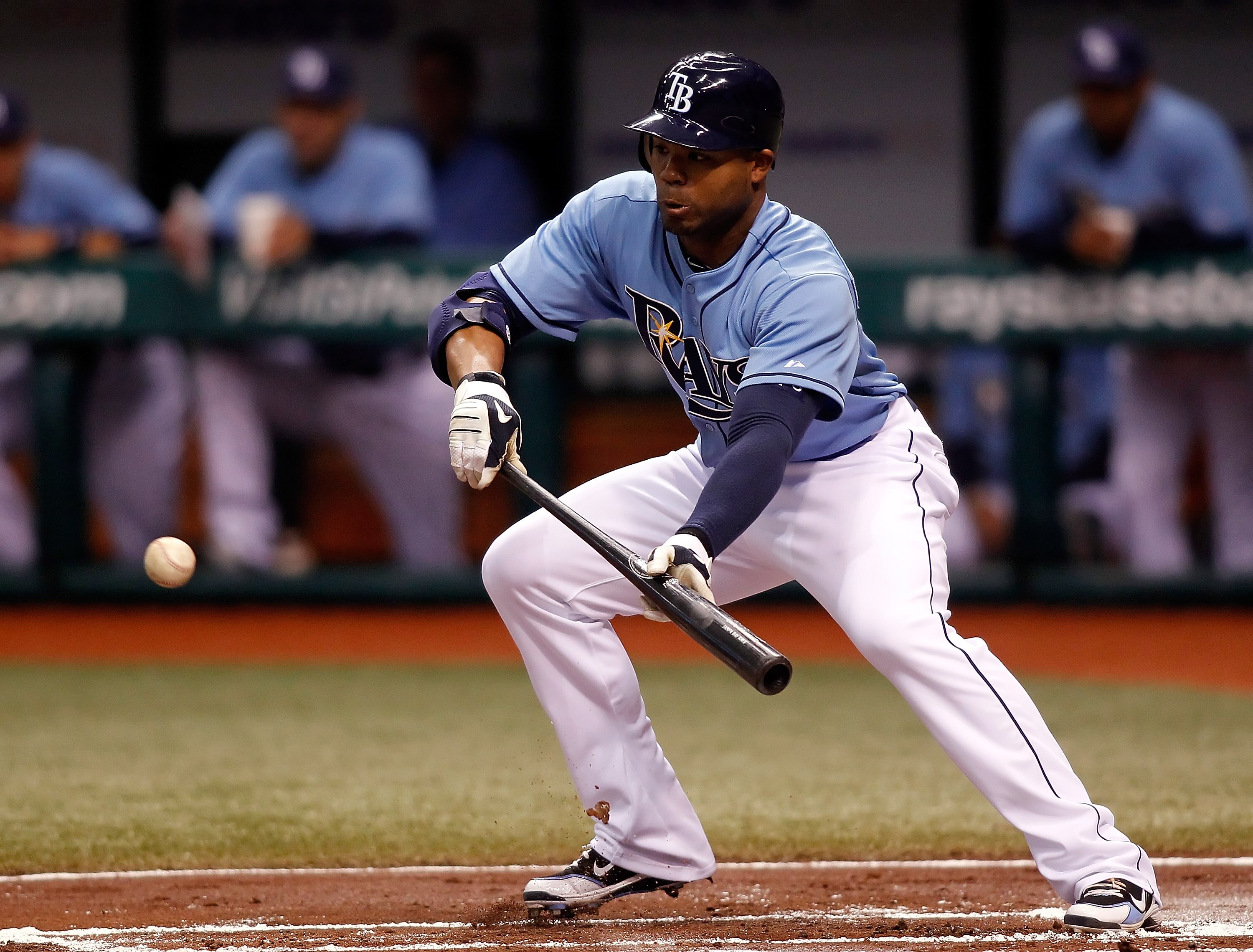ST. PETERSBURG - MAY 16:  Outfielder Carl Crawford #13 of the Tampa Bay Rays bunts against the Seattle Mariners during the game at Tropicana Field on May 16, 2010 in St. Petersburg, Florida.  (Photo by J. Meric/Getty Images)