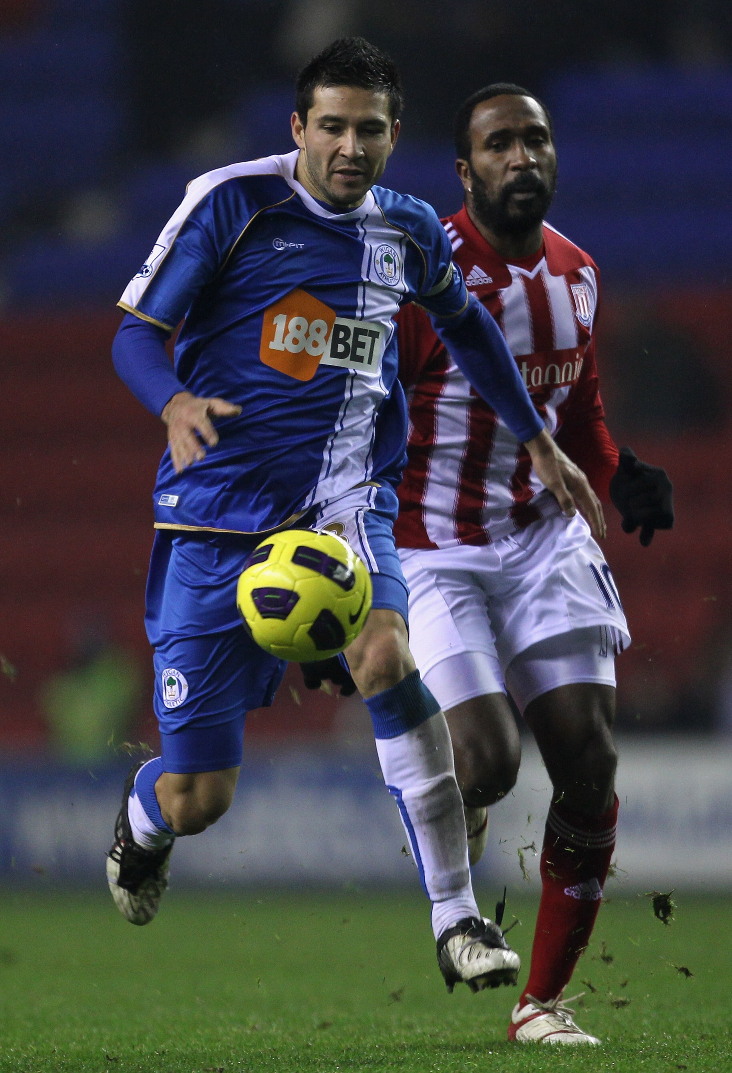 WIGAN, ENGLAND - DECEMBER 04:  Antolin Alcaraz of Wigan Athletic shields the ball from Ricardo Fuller of Stoke City during the Barclays Premier League match between Wigan Athletic and Stoke City at DW Stadium on December 4, 2010 in Wigan, England.  (Photo