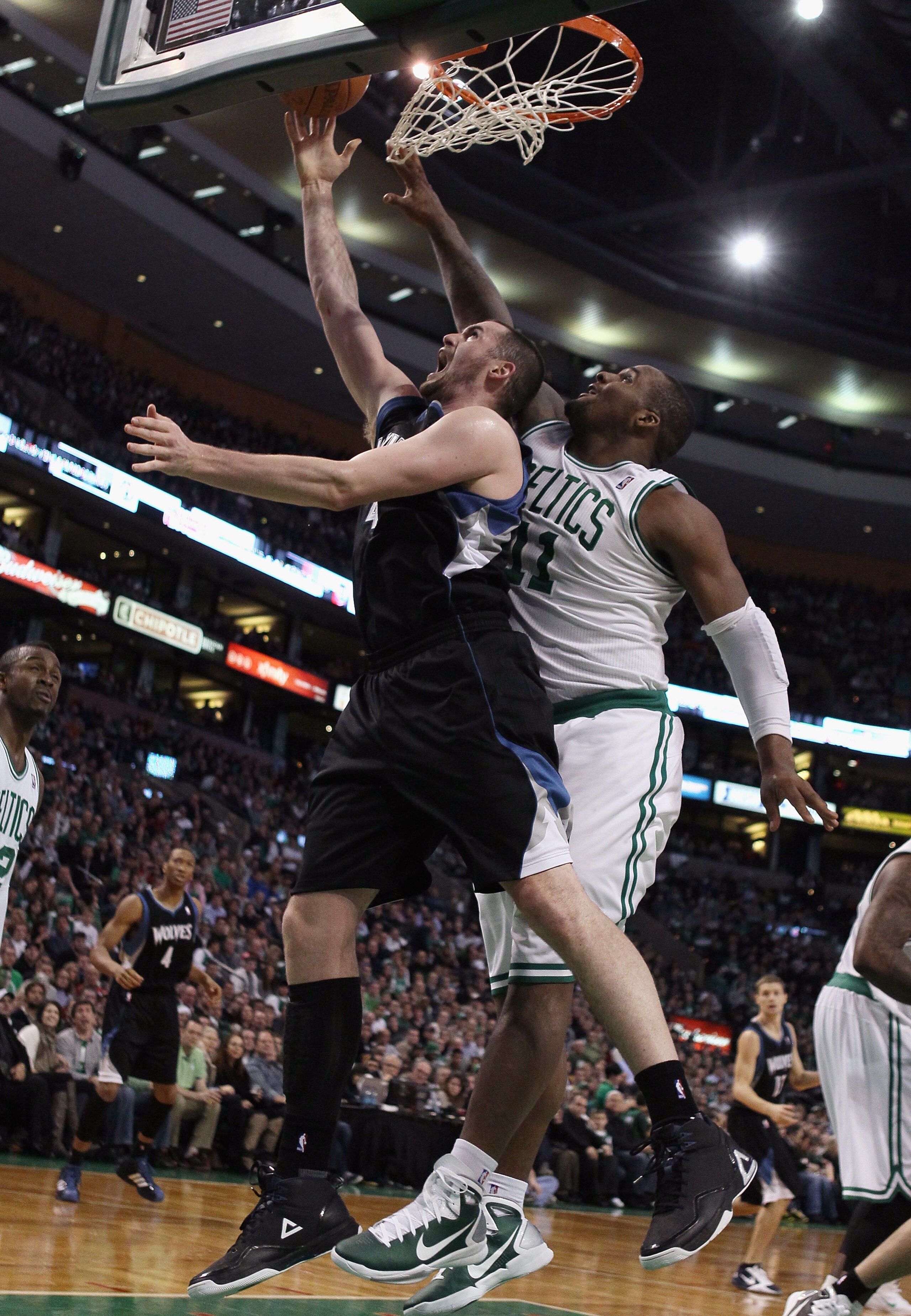 BOSTON, MA - JANUARY 03:  Kevin Love #42 of the Minnesota Timberwolves takes a shot as Glen Davis #11 of the Boston Celtics defends on January 3, 2011 at the TD Garden in Boston, Massachusetts. NOTE TO USER: User expressly acknowledges and agrees that, by