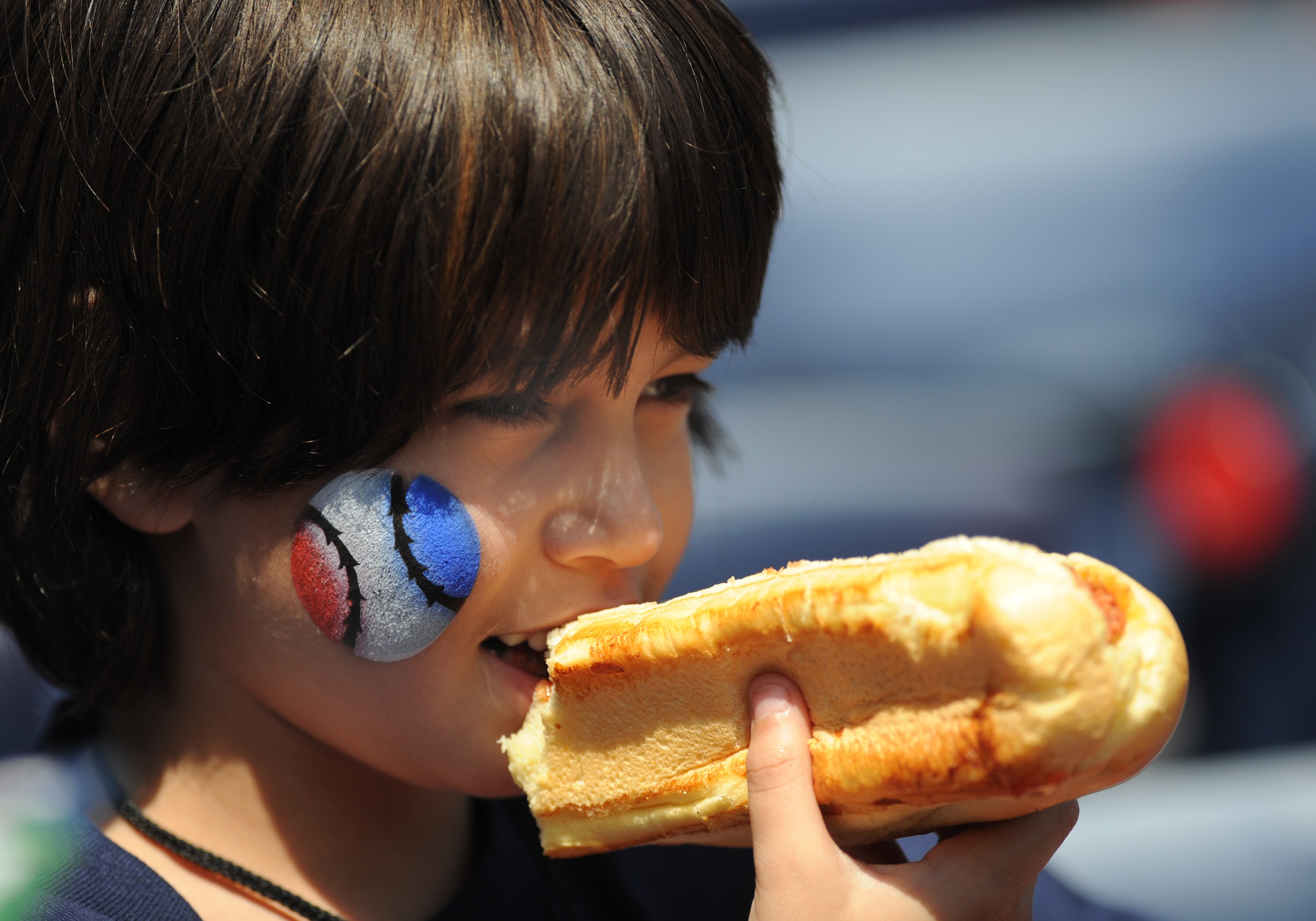 ATLANTA - APRIL 12: A young baseball fan enjoys a hot dog as the Atlanta Braves host the Washington Nationals April 12, 2009 at Turner Field in Atlanta, Georgia.  (Photo by Al Messerschmidt/Getty Images)
