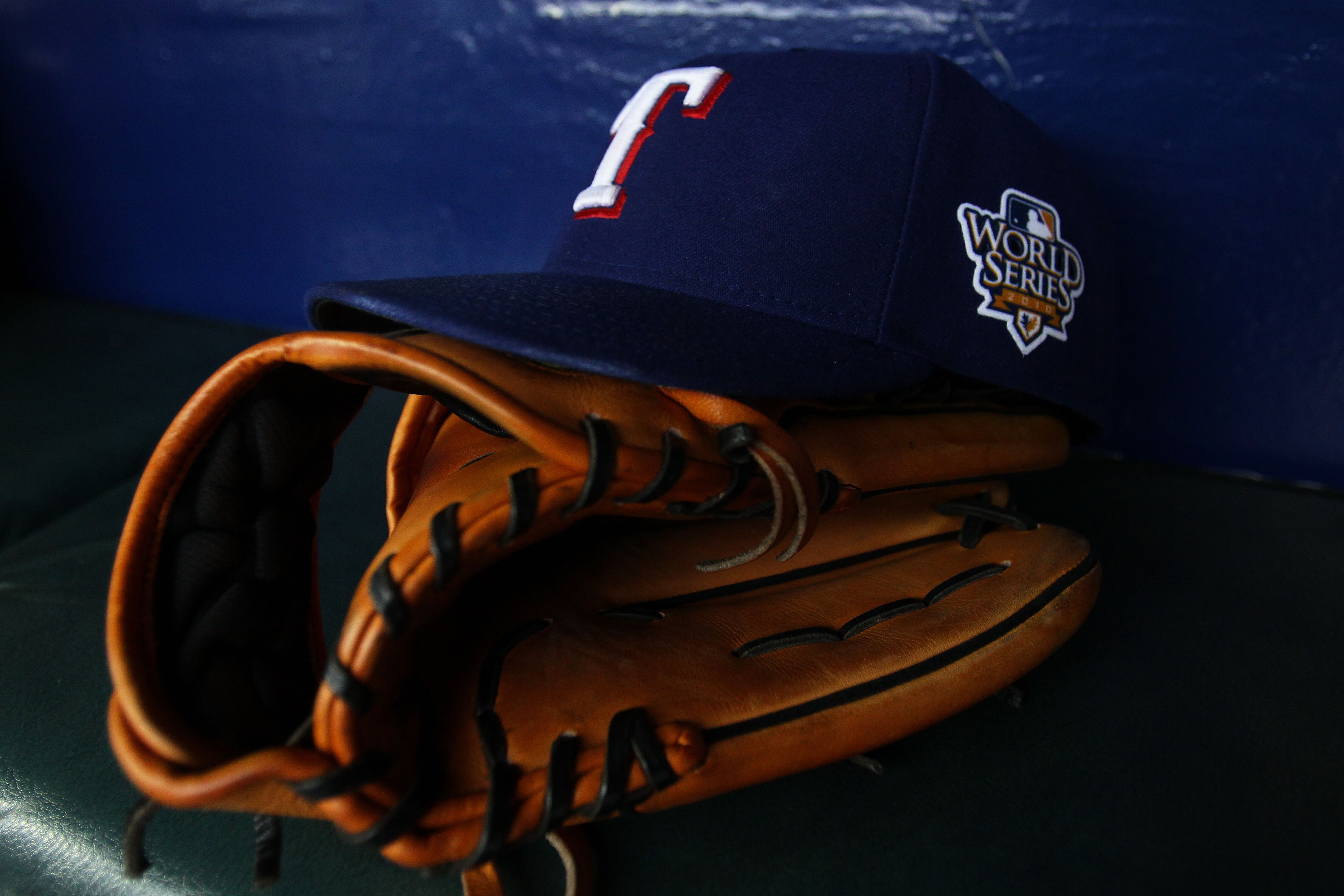 SAN FRANCISCO - OCTOBER 28:  A detailed picture of a Texas Rangers hat and glove in the dugout before Game Two of the 2010 MLB World Series against the San Francisco Giants at AT&T Park on October 28, 2010 in San Francisco, California.  (Photo by Jed Jaco
