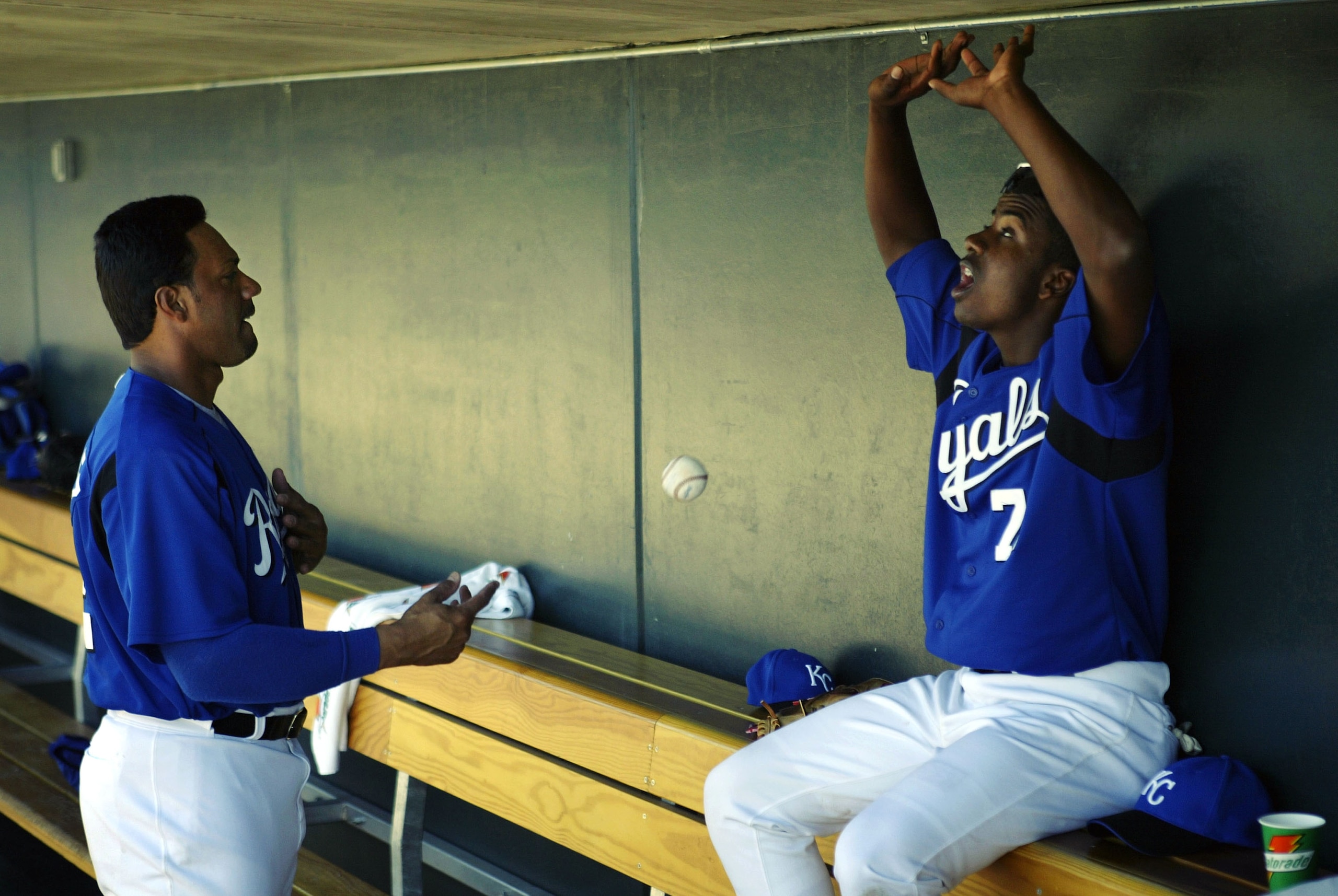 SURPRISE, AZ - MARCH 7:  Designated hitter Juan Gonzalez #22 tosses a ball off the dugout wall with Ruben Gotay #71 of the Kansas City Royals during a game against the Colorado Rockies on March 7, 2004 at Surprise Stadium in Surprise, Arizona.  (Photo by