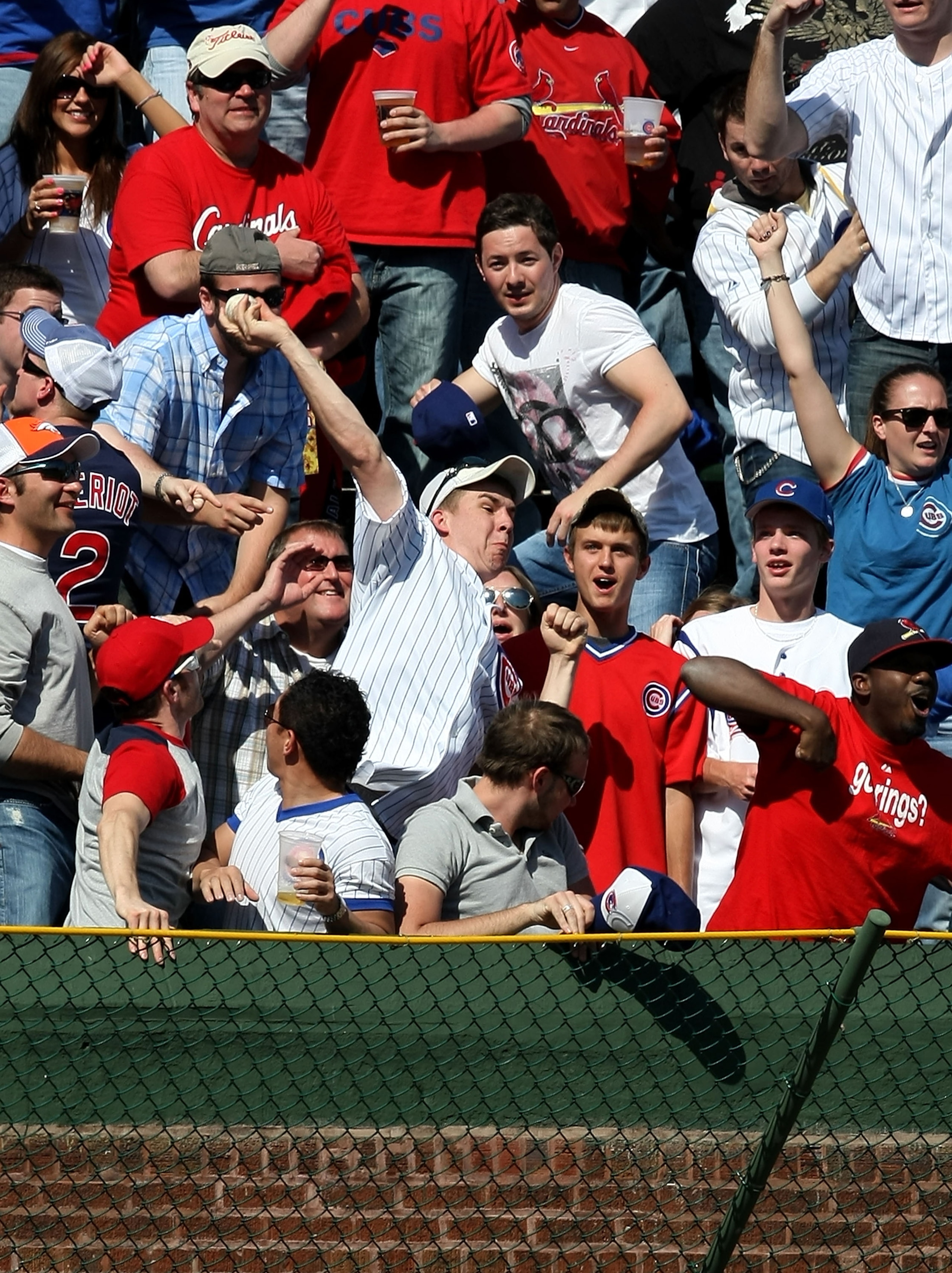 CHICAGO - APRIL 17: A Chicago Cubs fan in the left field bleachers throws back a home run ball hit by Ryan Ludwick of the St. Louis Cardinals in the 7th inning on April 17, 2009 at Wrigley Field in Chicago, Illinois. The Cubs defeated the Cardinals 8-7. (