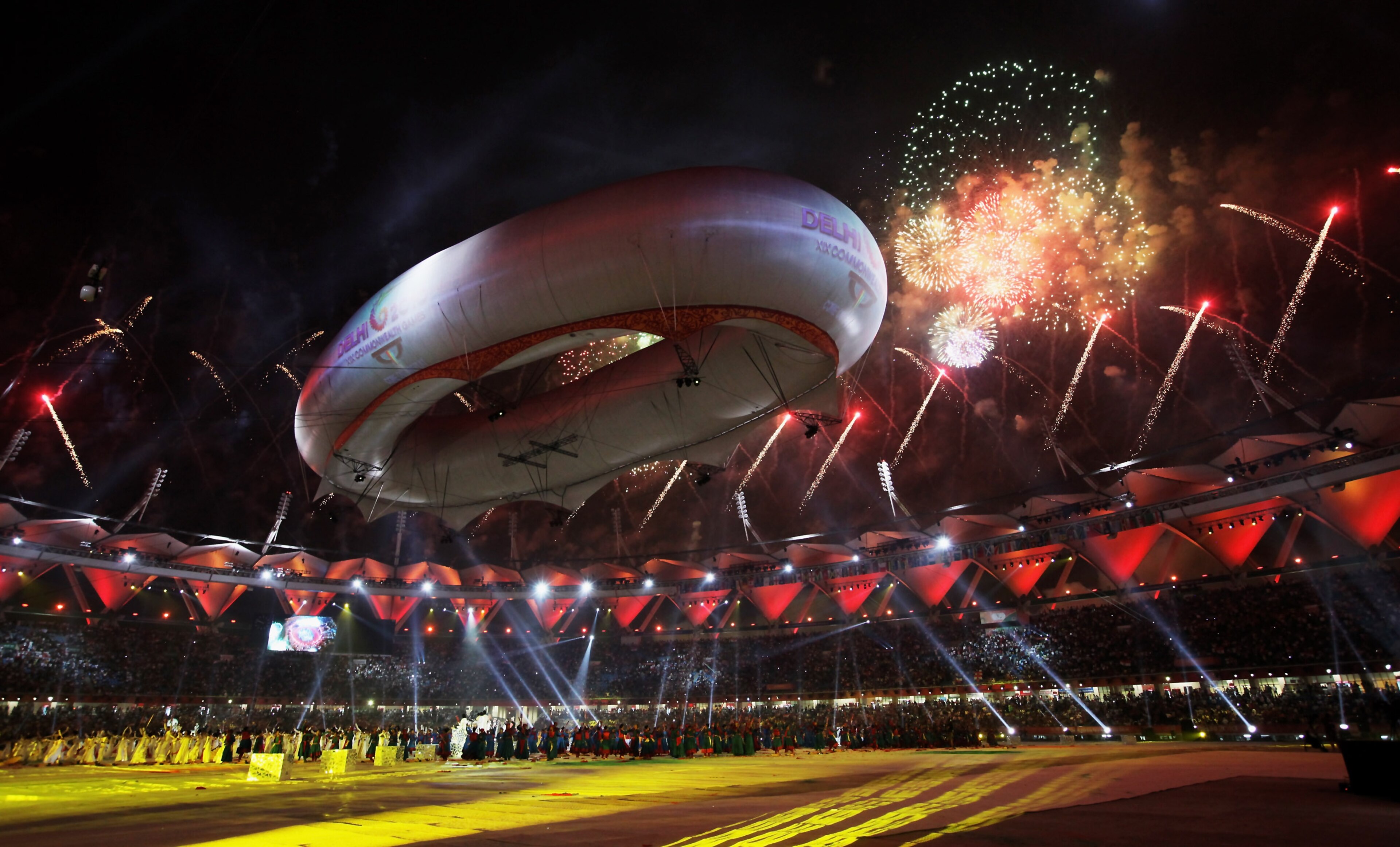 DELHI, INDIA - OCTOBER 14: Dancers perform during the finale as fireworks are discharged during the Closing Ceremony for the Delhi 2010 Commonwealth Games at Jawaharlal Nehru Stadium on October 14, 2010 in Delhi, India.  (Photo by Daniel Berehulak/Getty I