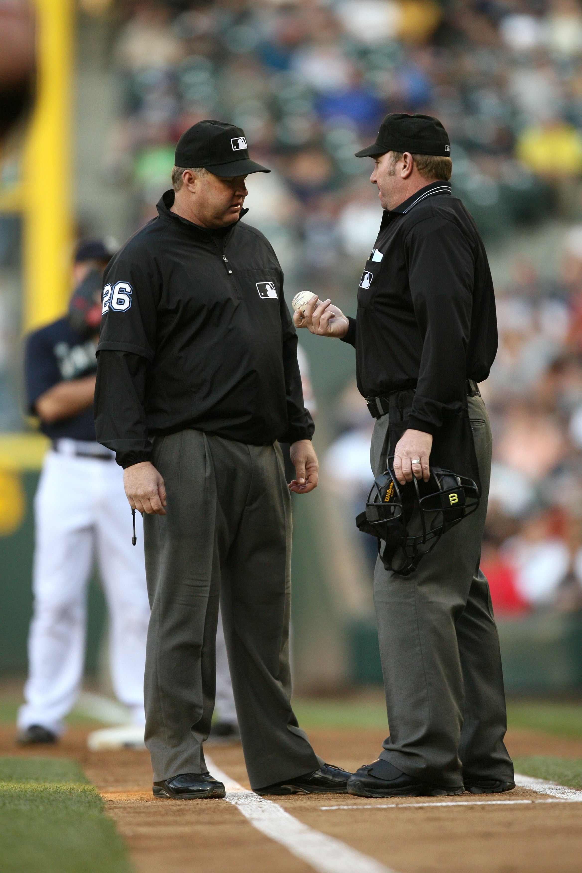 SEATTLE - MAY 22:  MLB home plate umpire Brian Runge and first base umpire Bill Miller #26 confer near the infield foul line during the game between the San Francisco Giants  and the Seattle Mariners on May 22, 2009 in Seattle, Washington. The Mariners de