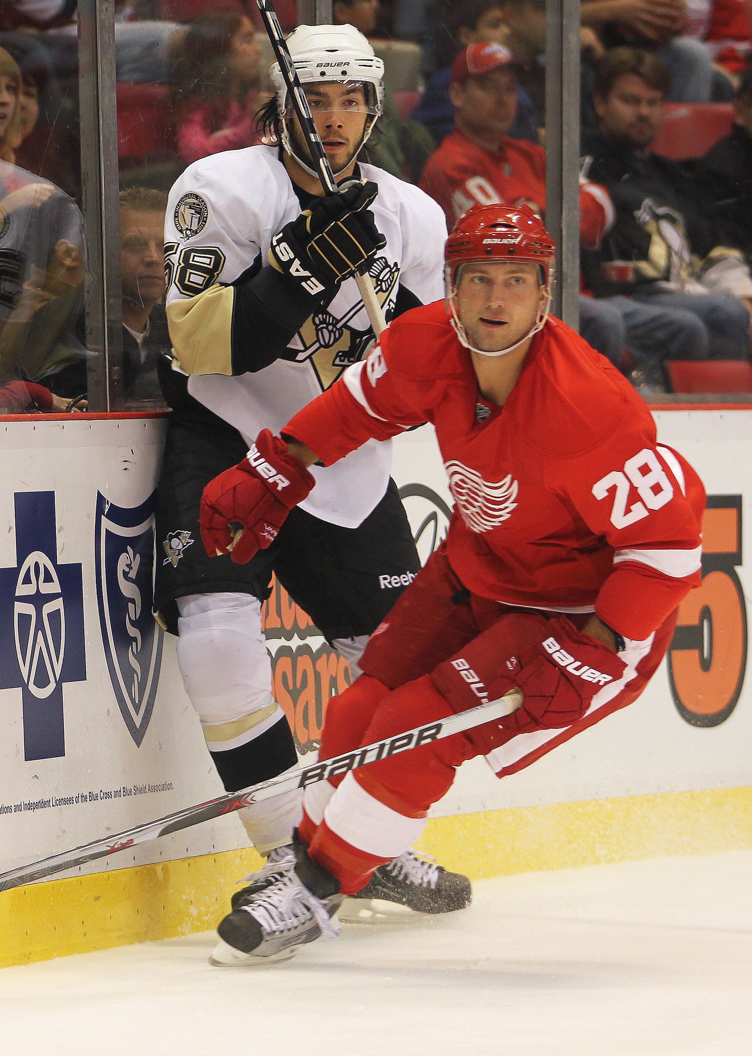DETROIT, MI - OCTOBER 03:  Brian Rafalski #28 of the Detroit Red Wings takes Kris Letang #58 of the Pittsburgh Penguins into the boards in a preseason game on October 3, 2010 at the Joe Louis Arena in Detroit, Michigan. The Penguins defeated the Red Wings