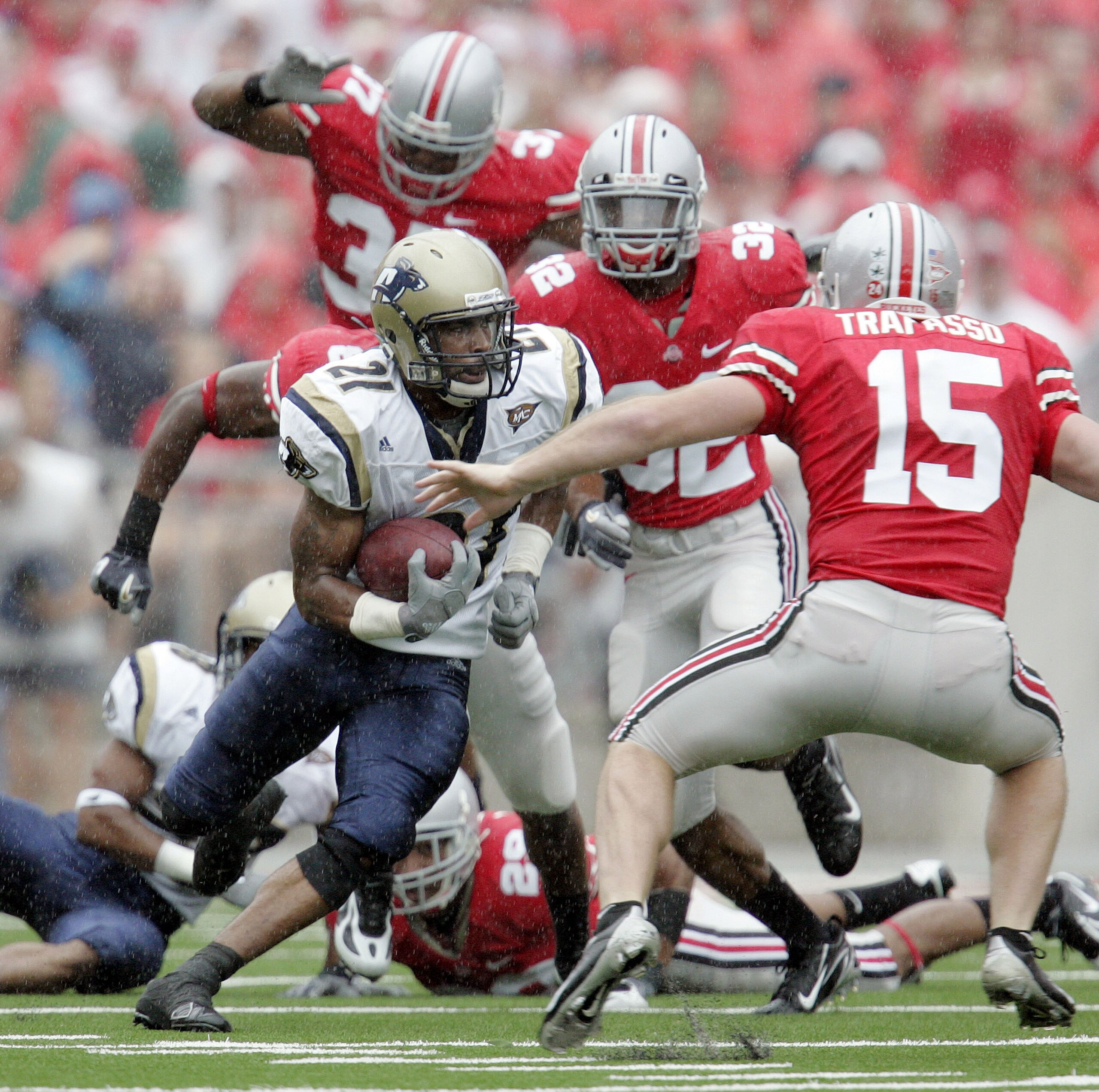 COLUMBUS - SEPTEMBER 8:  Andre Jones #21 of the Akron Zips carries the ball as he is chased by Thaddeus Gibson #37, Eugene Clifford #32 and A.J. Trapasso #15 of the Ohio State Buckeyes during the first half on September 8, 2007 at Ohio Stadium in Columbus