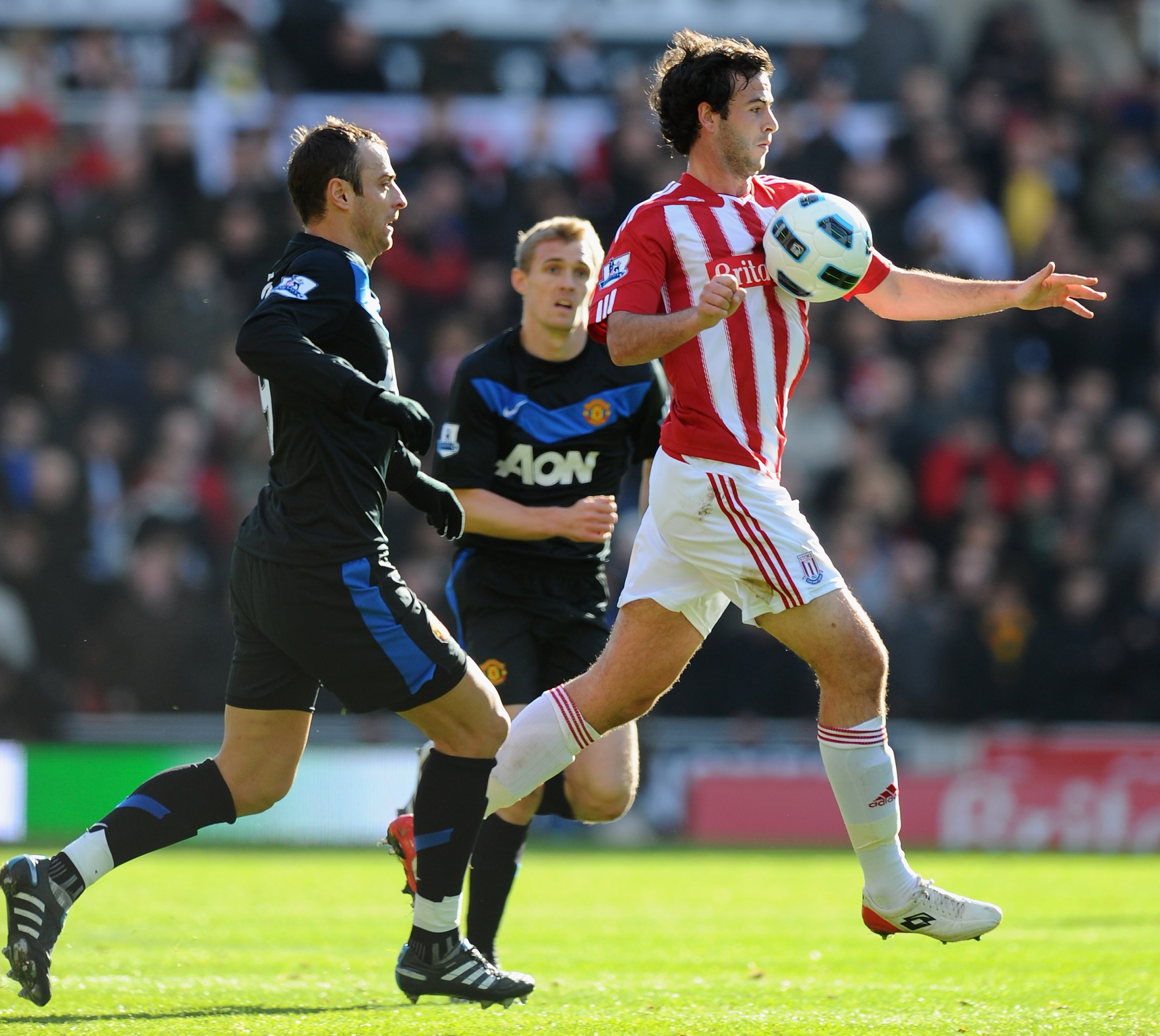 STOKE ON TRENT, ENGLAND - OCTOBER 24:  Marc Wilson of Stoke controls the ball ahead of Dimitar Berbatov of Manchester United  during the Barclays Premier League match between Stoke City and Manchester United at Britannia Stadium on October 24, 2010 in Sto