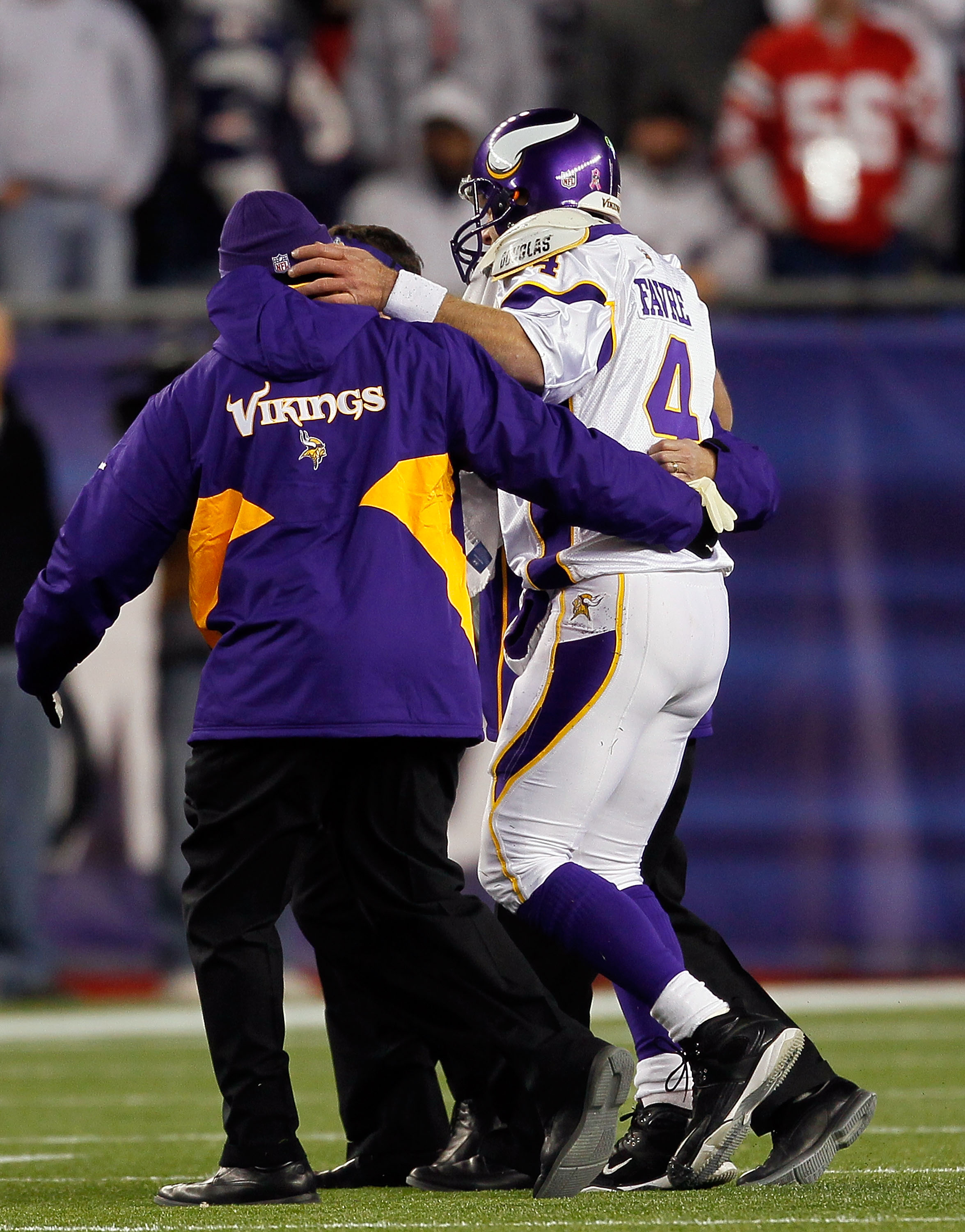 FOXBORO, MA - OCTOBER 31:  Brett Favre #4 of the Minnesota Vikings is helped to the bench after he was hit by Myron Pryor #91 of the New England Patriots in the fourth quarter at Gillette Stadium on October 31, 2010 in Foxboro, Massachusetts. Favre was in