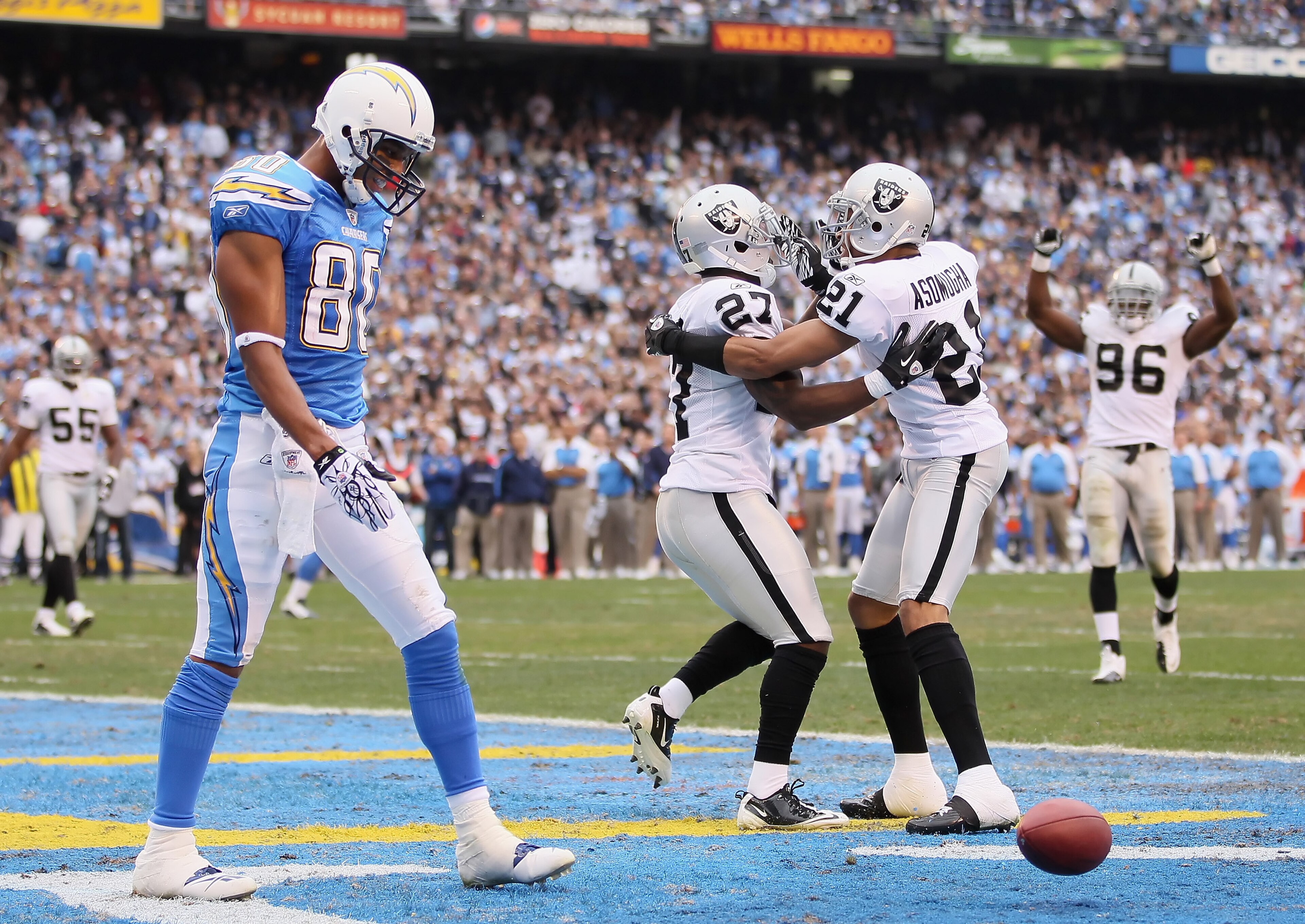 SAN DIEGO - DECEMBER 05:  (L-R) Wide receiver Malcolm Floyd #80 of the San Diego Chargers looks down, as Stevie Brown #27 and Nnamdi Asomugha #21 the Oakland Raiders celebrate a broken play in the third quarter at Qualcomm Stadium on December 5, 2010 in S