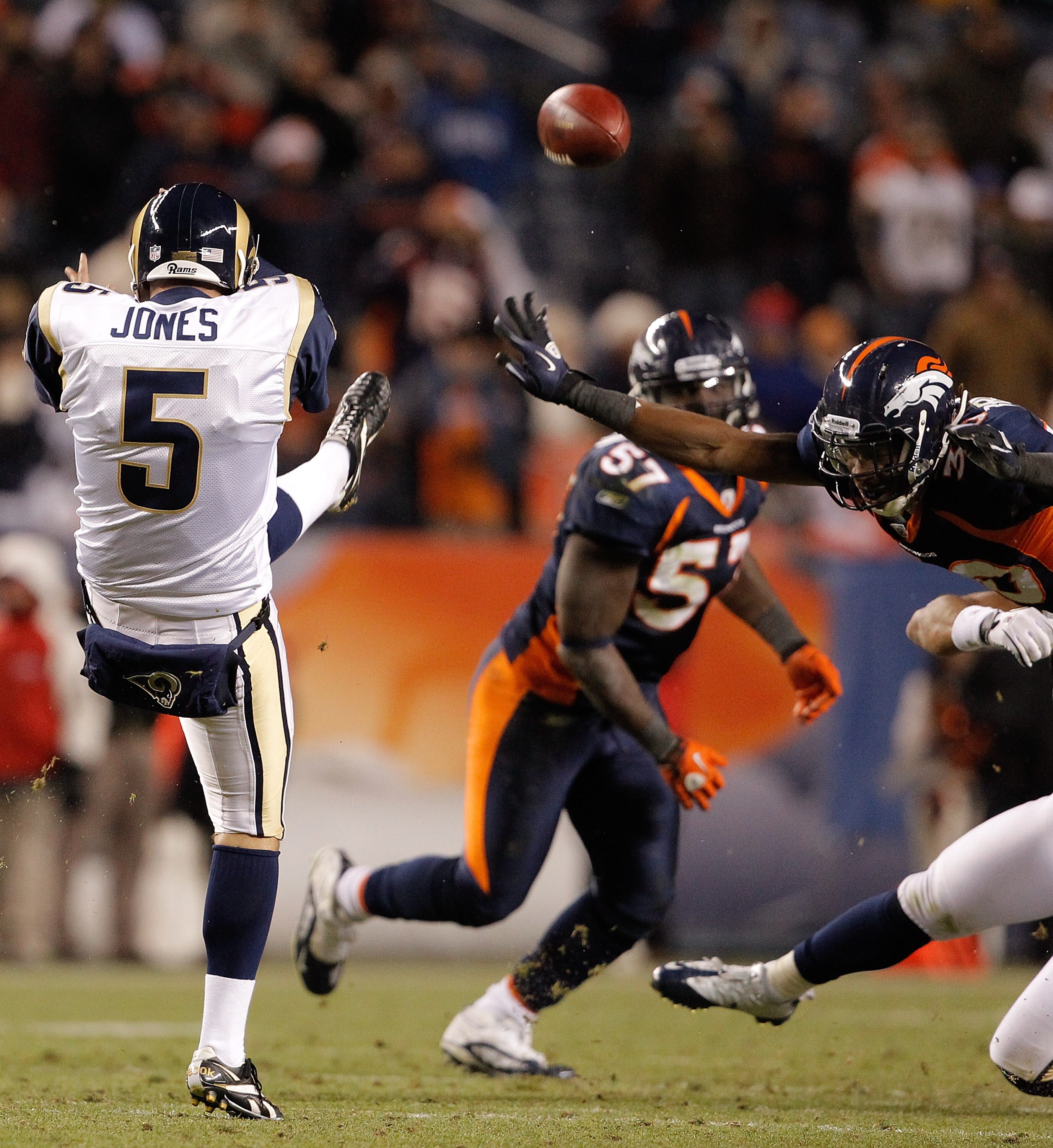DENVER - NOVEMBER 28:  Safety David Bruton #30 of the Denver Broncos blocks a punt by punter Donnie Jones #5 of the St. Louis Rams during the fourth quarter at INVESCO Field at Mile High on November 28, 2010 in Denver, Colorado. The Rams defeated the Bron