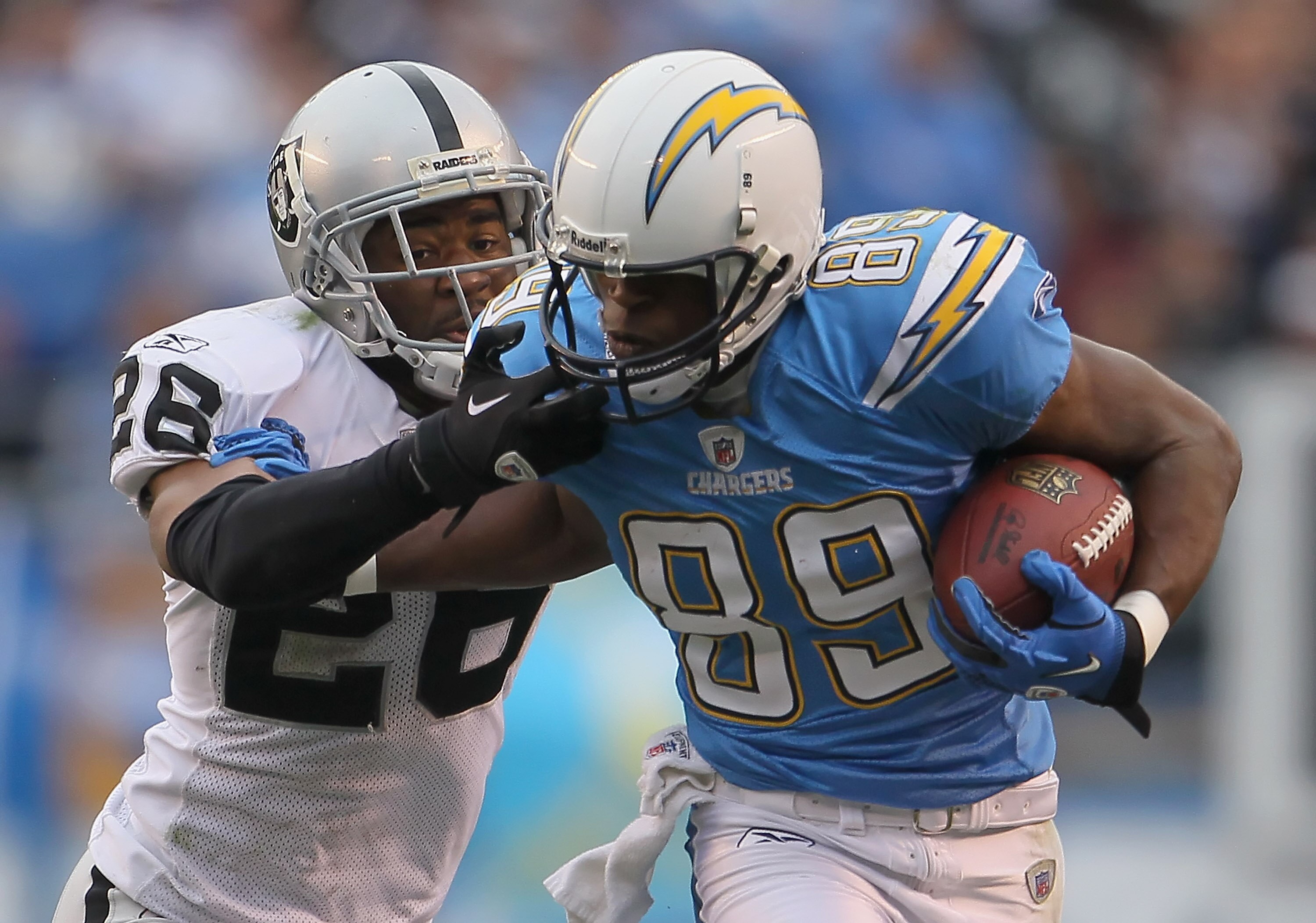 SAN DIEGO - DECEMBER 05:  Stanford Routt #26 of the Oakland Raiders grabs the face mask of Seyi Ajirotutu #89 of the San Diego Chargers in an attempt to bring him down in the third quarter at Qualcomm Stadium on December 5, 2010 in San Diego, California. 