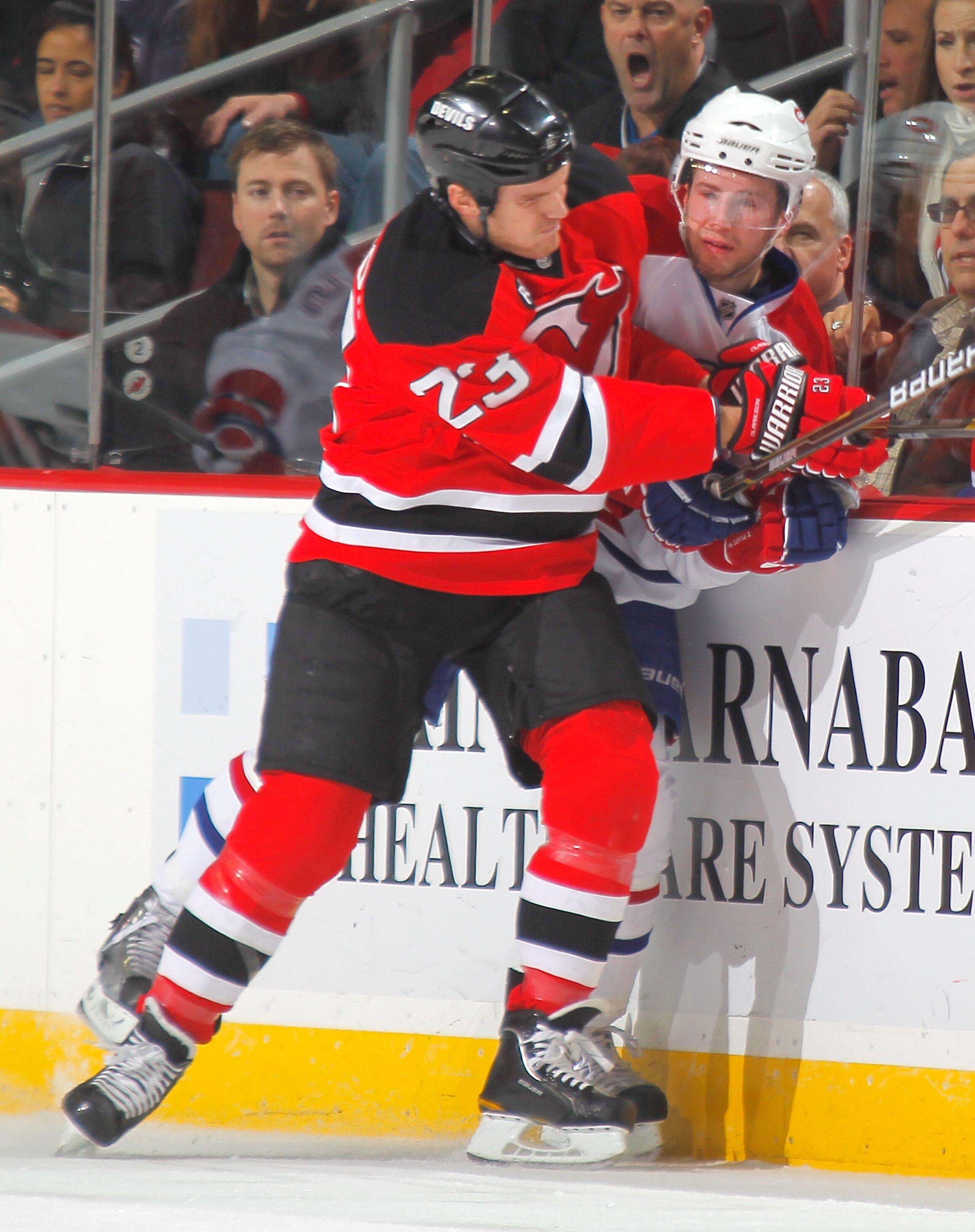 NEWARK, NJ - DECEMBER 02:  Tom Pyatt #94 of the Montreal Canadiens is checked by David Clarkson #23 of the New Jersey Devils during the third period of a hockey game at the Prudential Center on December 2, 2010 in Newark, New Jersey.  (Photo by Paul Beres