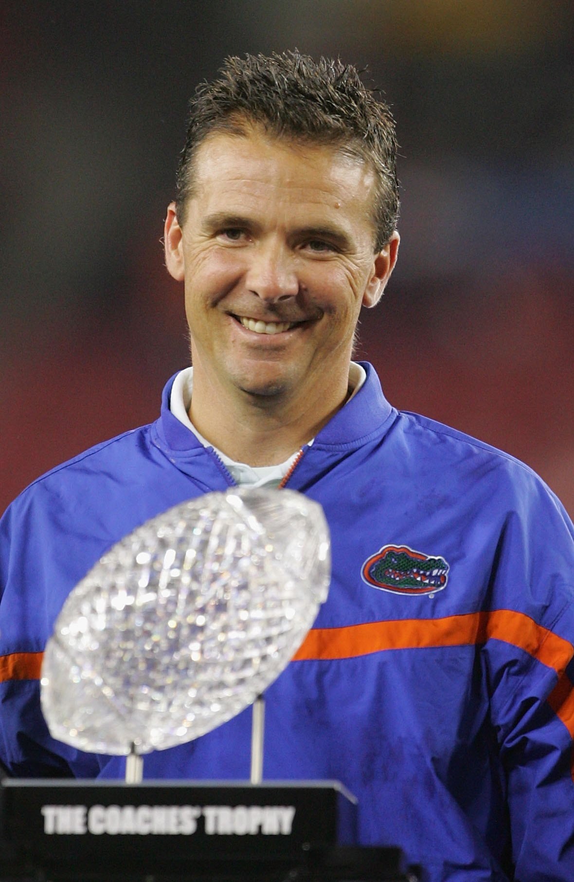 GLENDALE, AZ - JANUARY 08:  Head coach Urban Meyer of the Florida Gators smile while the BCS Championship trophy awaits him in the forground after defeating the Ohio State Buckeyes 41-14 during the 2007 Tostitos BCS National Championship Game at the Unive
