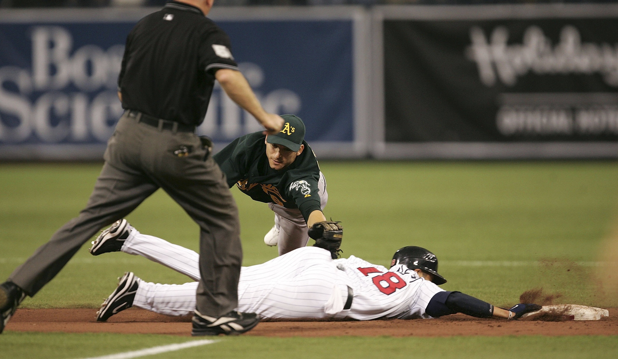 MINNEAPOLIS - OCTOBER 3:  Jason Barlett #18 of the Minnesota Twins gets safely back to second base as Marco Scutaro #19 of the Oakland Athletics dives to tag him in Game One of the American League Division Series at the Hubert H. Humphrey Metrodome Octobe
