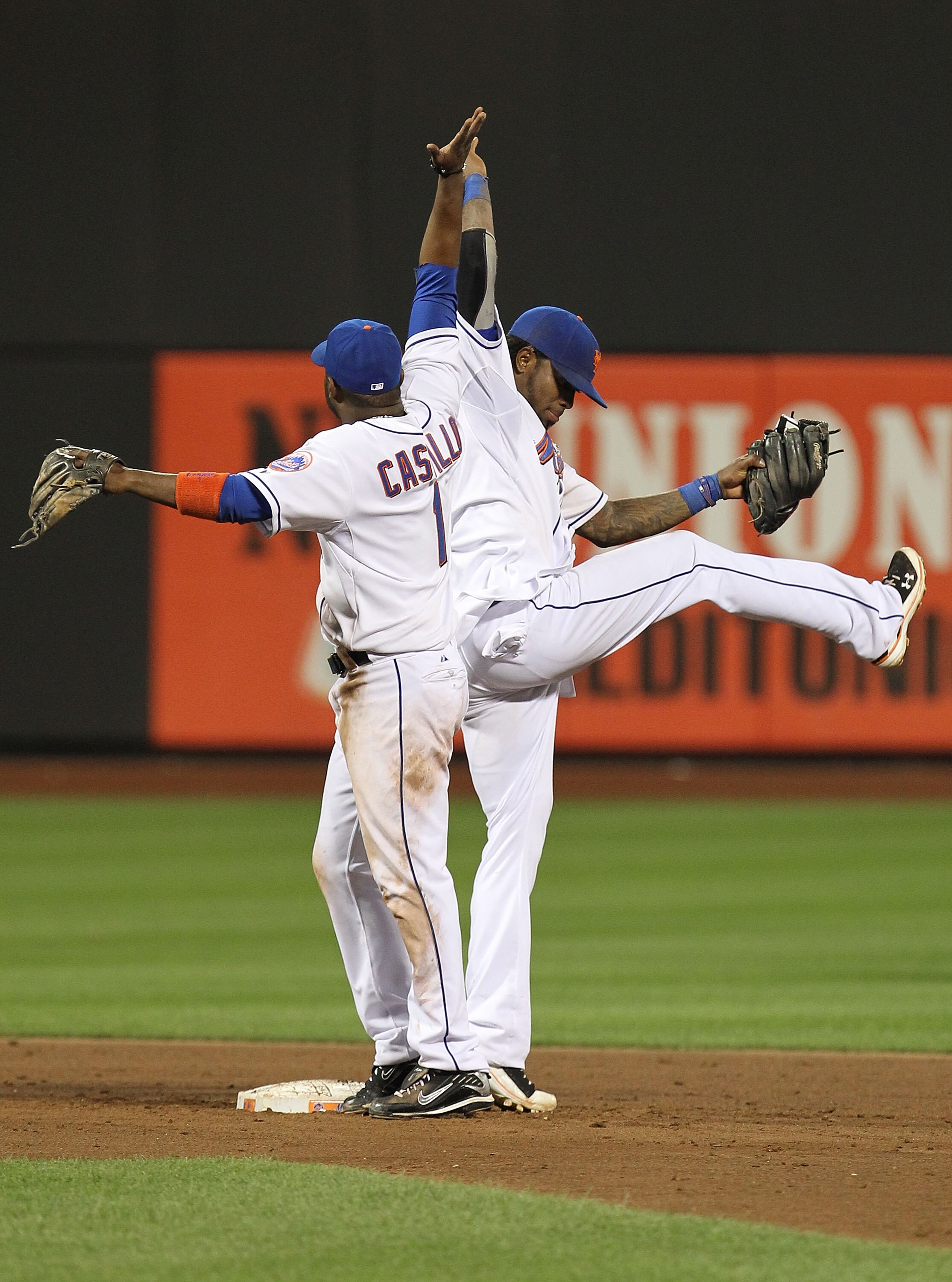 NEW YORK - JULY 27:  Jose Reyes #7 and Luis Castillo #1 of the New York Mets celebrate an 8-2 win against the St. Louis Cardinals on July 27, 2010 at Citi Field in the Flushing neighborhood of the Queens borough of New York City.  (Photo by Al Bello/Getty