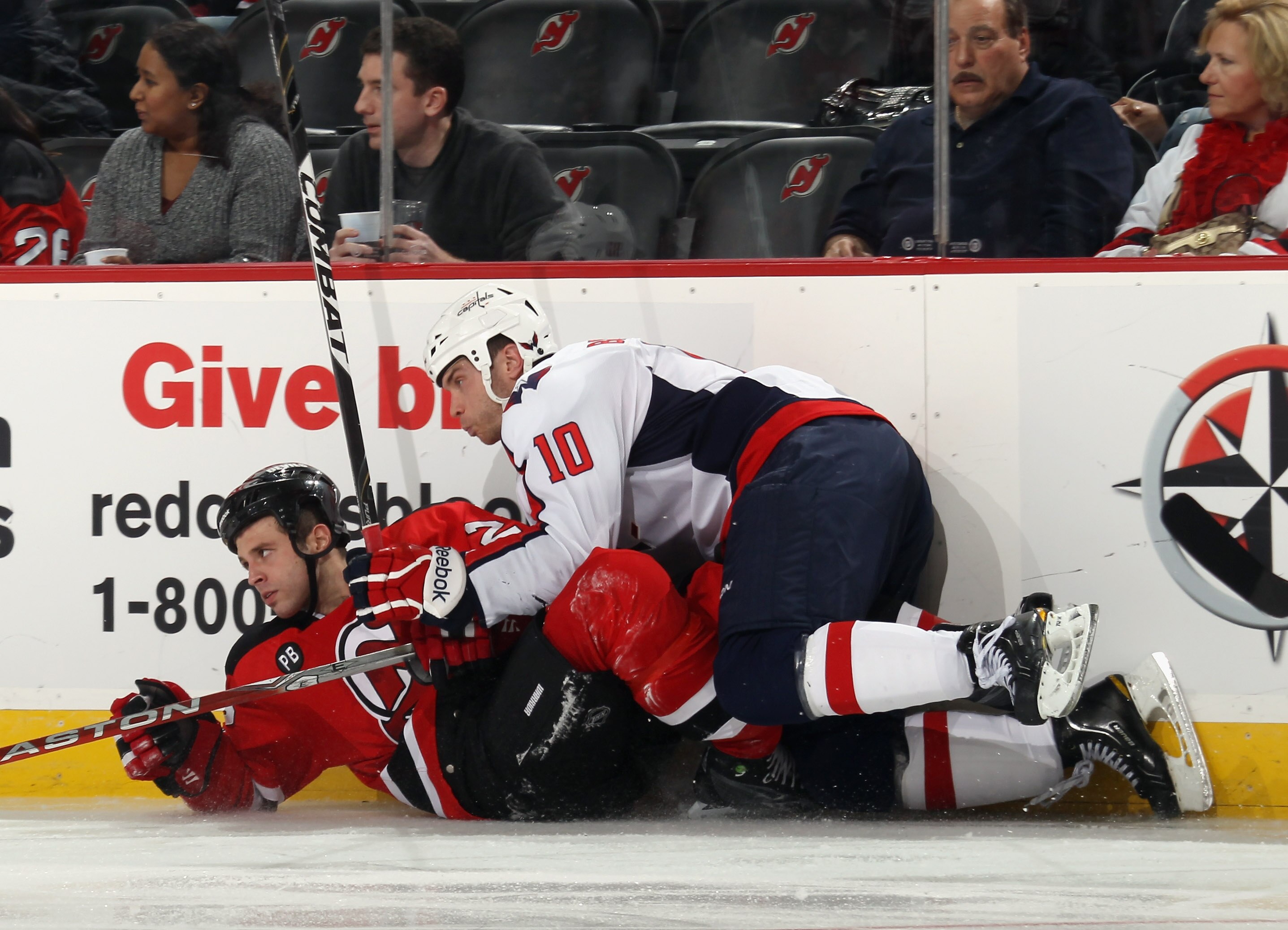 NEWARK, NJ - NOVEMBER 22: Matthew Corrente #22 of the New Jersey Devils is taken down by Matt Bradley #10 of the Washington Capitals at the Prudential Center on November 22, 2010 in Newark, New Jersey.  (Photo by Bruce Bennett/Getty Images)