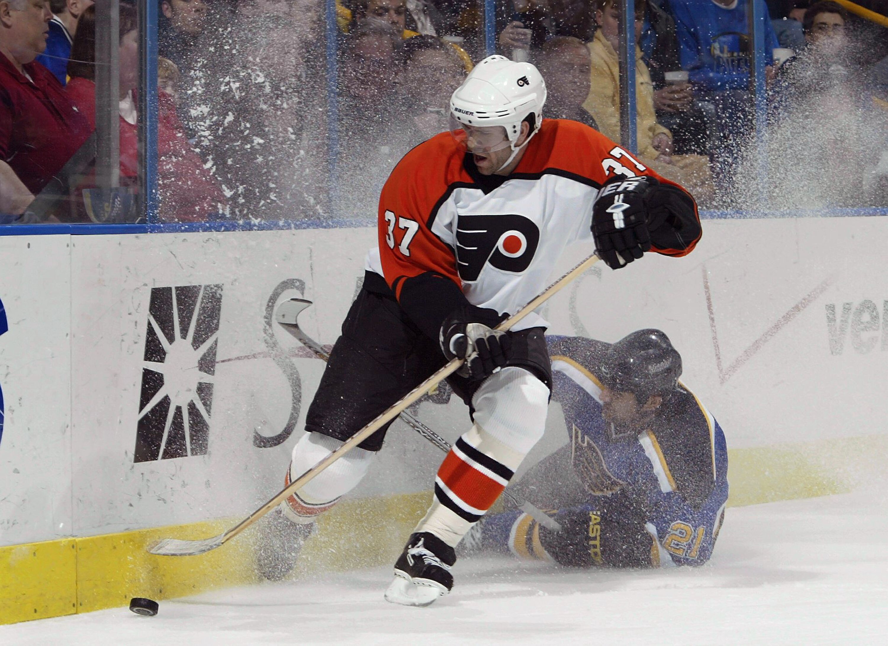 ST. LOUIS - DECEMBER 30:  Eric Desjardins #37 of the Philadelphia Flyers beats Jamal Mayers #21 of the St. Louis Blues to the puck on December 30, 2003 at the Savvis Center in St. Louis, Missouri.  (Photo by Elsa/Getty Images)