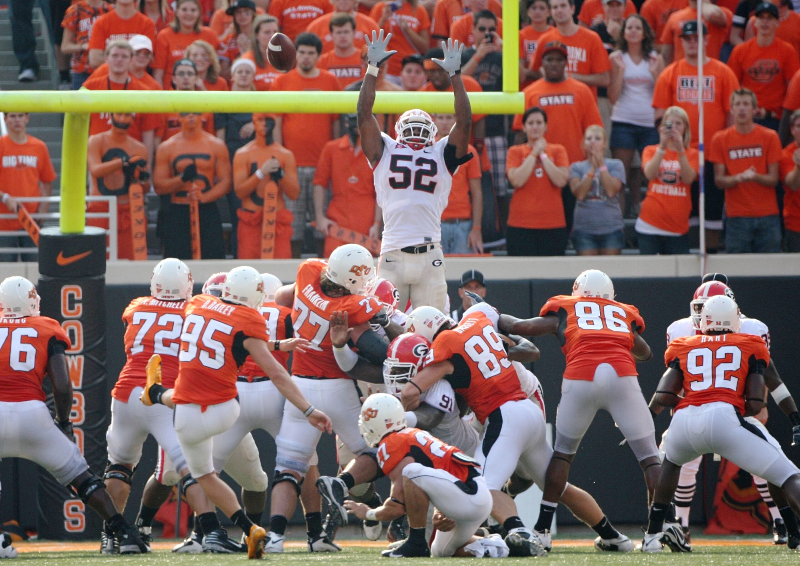 STILLWATER, OK - SEPTEMBER 5: Kicker Dan Bailey #95 of the Oklahoma State Cowboys kicks for the extra point  as Darius Dewberry #52 of the Georgia Bulldogs tries to block in the fourth quarter of the game at Boone Pickens Stadium on September 5, 2009 in S