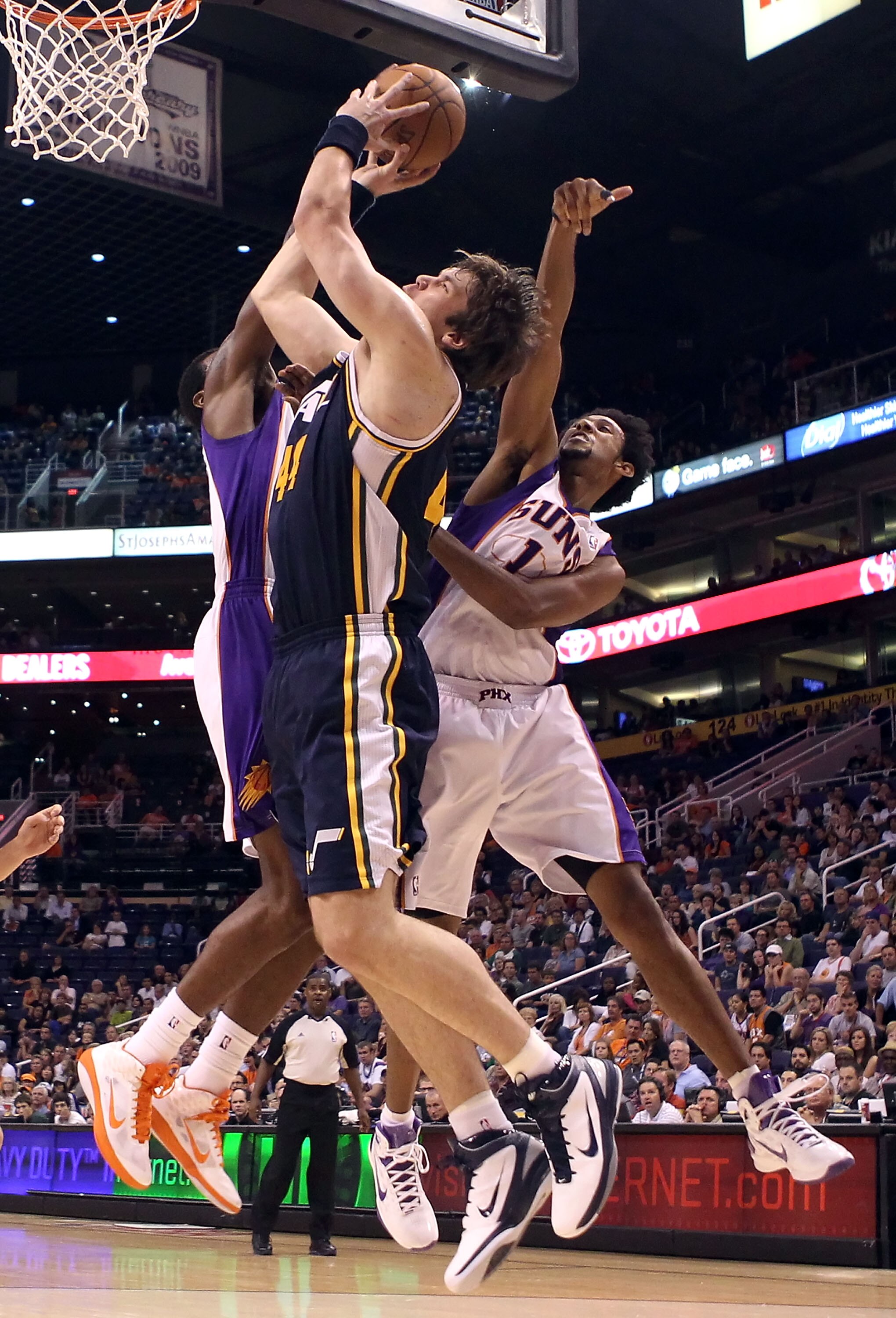 PHOENIX - OCTOBER 12:  Kyrylo Fesenko #44 of the Utah Jazz puts up a shot past Josh Childress #1 of the Phoenix Suns during the preseason NBA game at US Airways Center on October 12, 2010 in Phoenix, Arizona. NOTE TO USER: User expressly acknowledges and