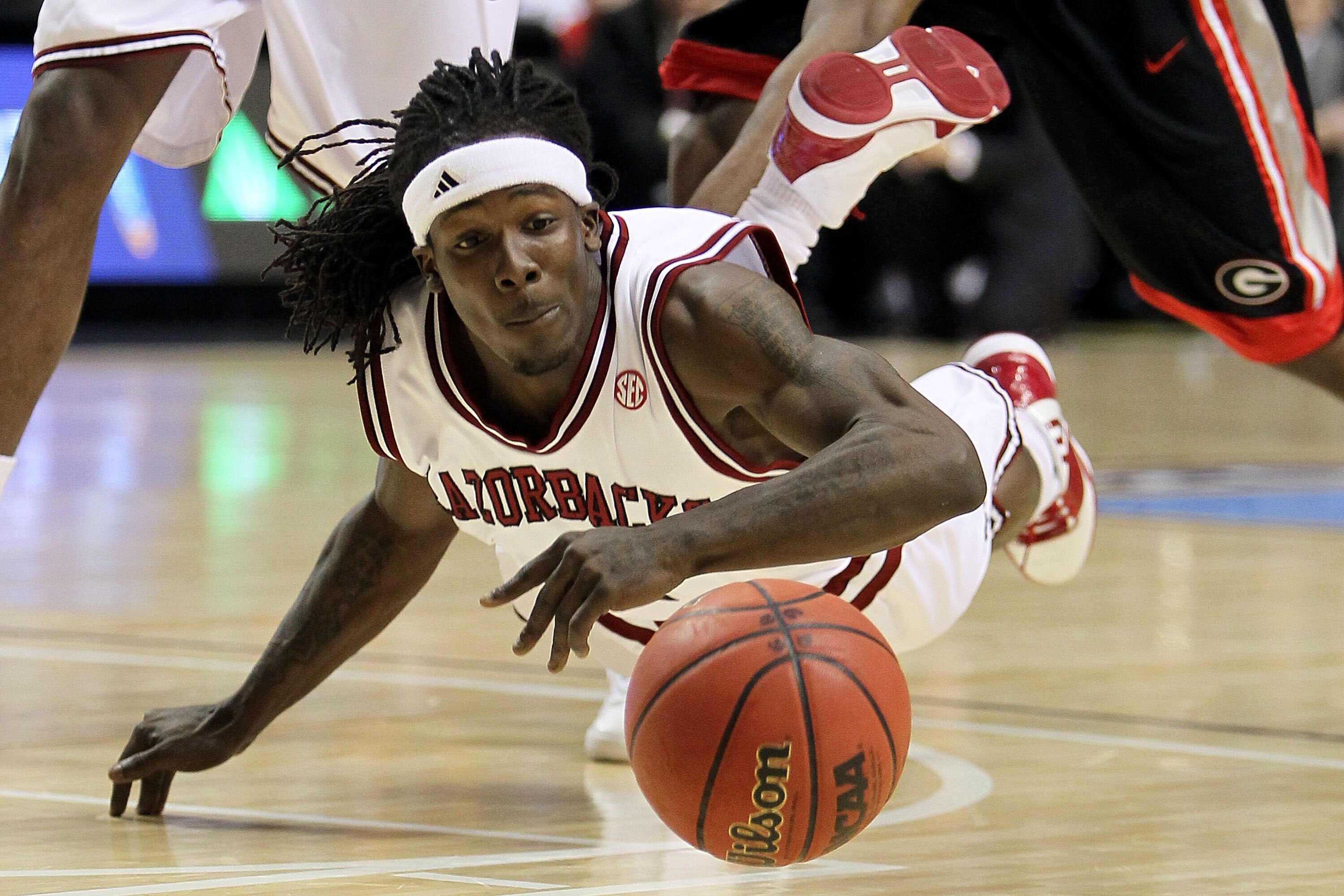 NASHVILLE, TN - MARCH 11:  Courtney Fortson #4 of the Arkanasas Razorbacks dives for a loose ball against the Georgia Bulldogs during the first round of the SEC Men's Basketball Tournament at the Bridgestone Arena on March 11, 2010 in Nashville, Tennessee