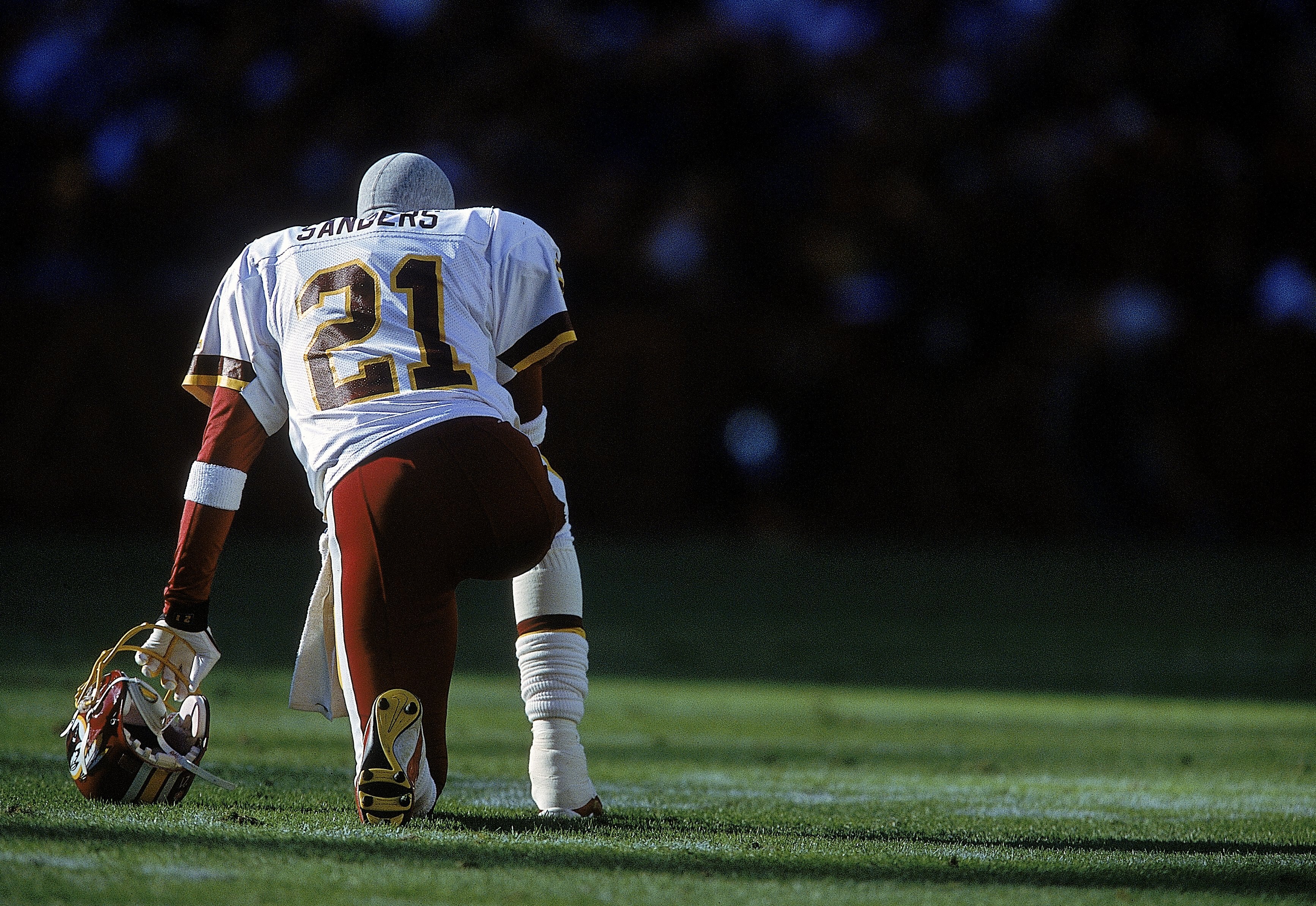 26 Nov 2000: Deion Sanders #21 of the Washington Redskins kneels on the field before the game against the Philadelphia Eagles at the FedEx Field in Landover, Maryland. The Eagles defeated the Redskins 23-20.Mandatory Credit: Jamie Squire  /Allsport