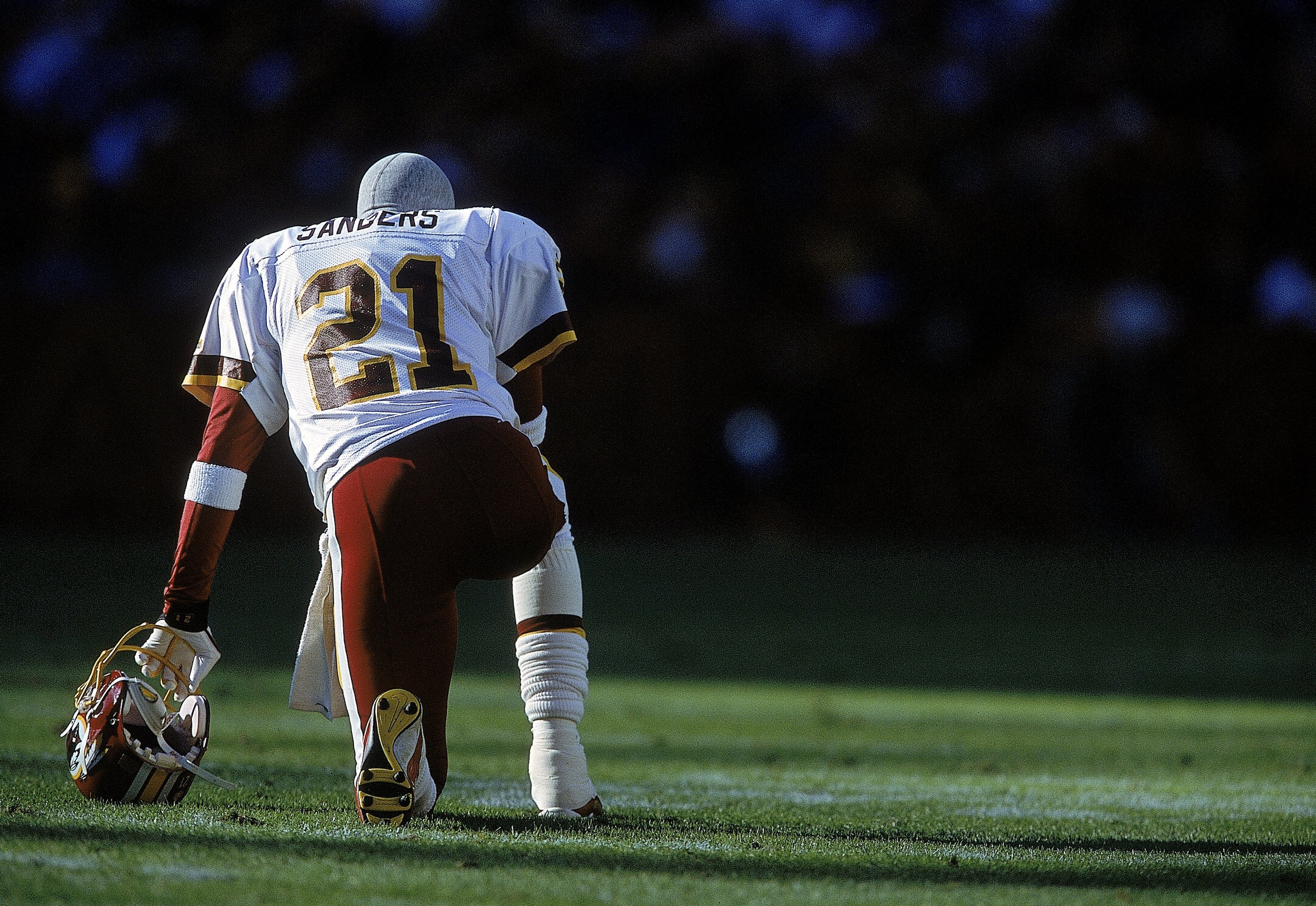 26 Nov 2000: Deion Sanders #21 of the Washington Redskins kneels on the field before the game against the Philadelphia Eagles at the FedEx Field in Landover, Maryland. The Eagles defeated the Redskins 23-20.Mandatory Credit: Jamie Squire  /Allsport