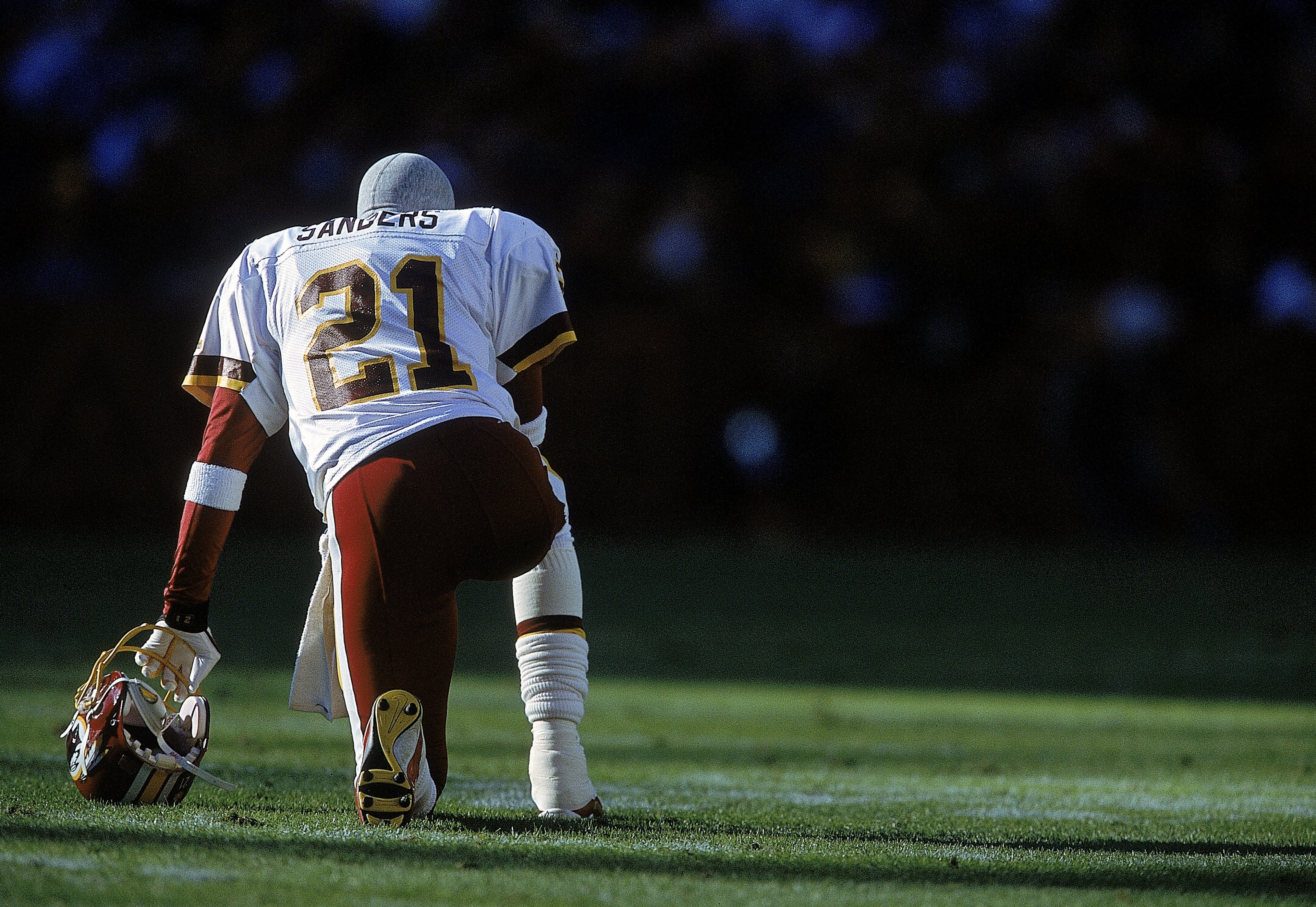 26 Nov 2000: Deion Sanders #21 of the Washington Redskins kneels on the field before the game against the Philadelphia Eagles at the FedEx Field in Landover, Maryland. The Eagles defeated the Redskins 23-20.Mandatory Credit: Jamie Squire  /Allsport