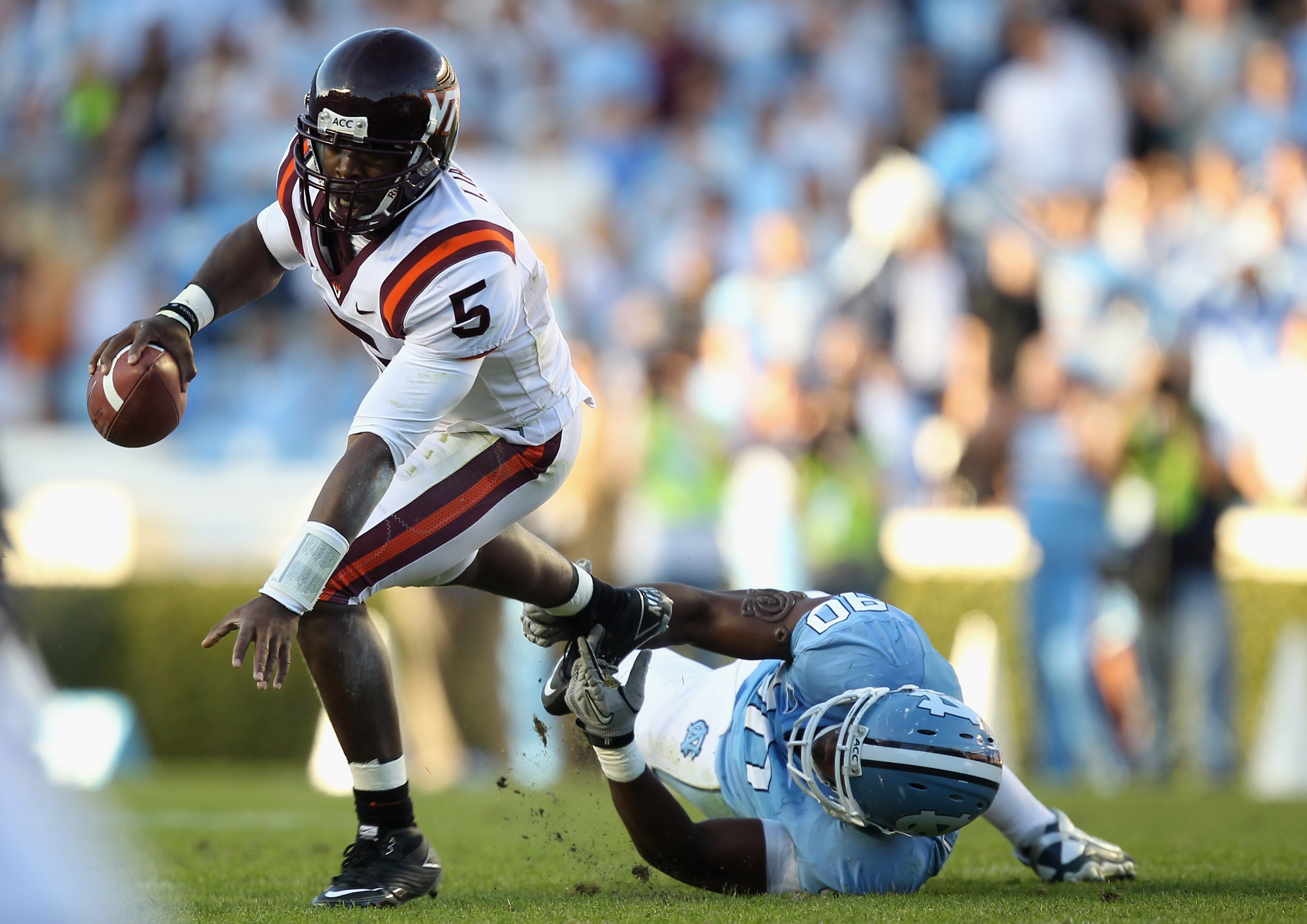 CHAPEL HILL, NC - NOVEMBER 13:  Tyrod Taylor #5 of the Virginia Tech Hokies tries to get away from Quinton Coples #90 of the North Carolina Tar Heels during their game at Kenan Stadium on November 13, 2010 in Chapel Hill, North Carolina.  (Photo by Street