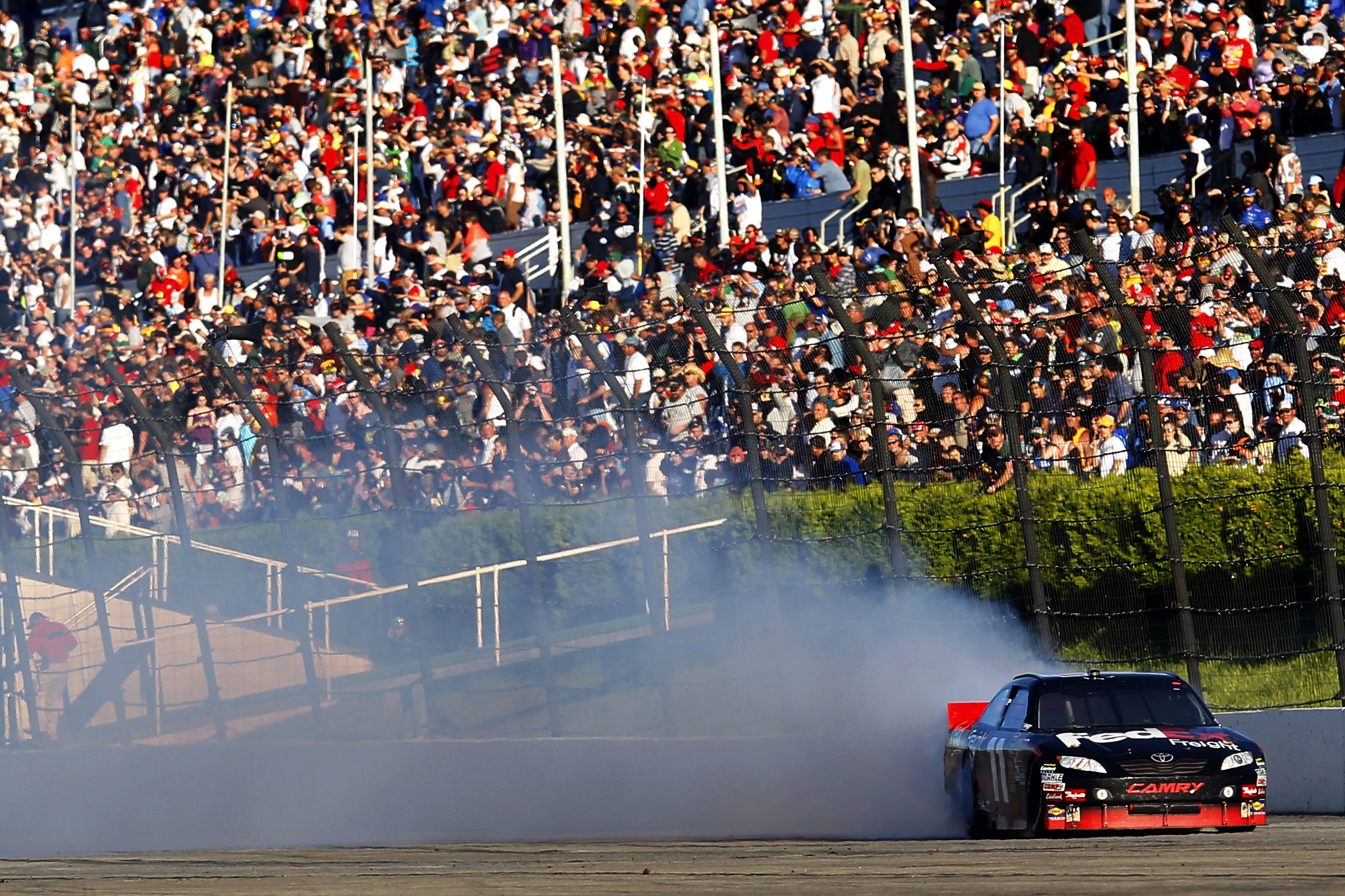 LONG POND, PA - JUNE 06:  Denny Hamlin, driver of the #11 FedEx Freight Toyota, preforms a burnout after winning the NASCAR Sprint Cup Series Gillette Fusion ProGlide 500 at Pocono Raceway on June 6, 2010 in Long Pond, Pennsylvania.  (Photo by Chris Trotm