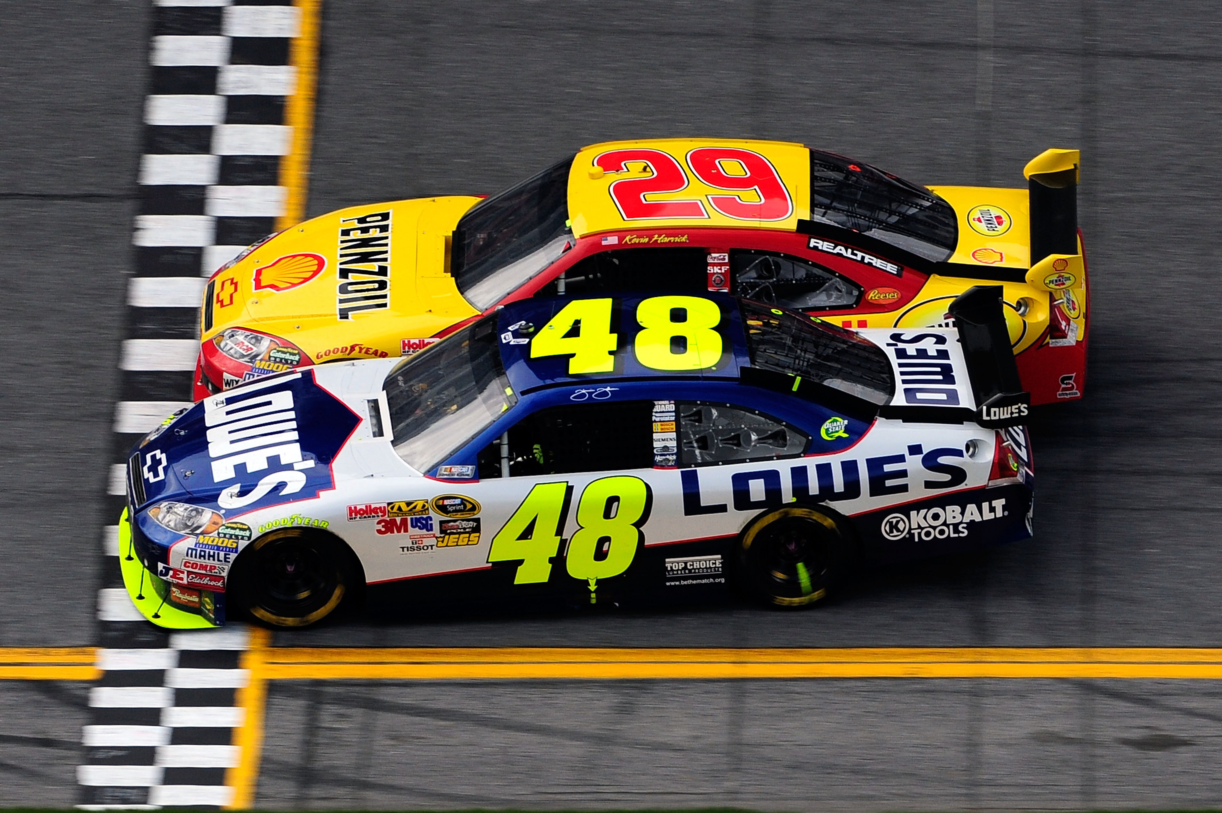 DAYTONA BEACH, FL - FEBRUARY 11:  Jimmie Johnson, driver of the #48 Lowe's Chevrolet, crosses the finish line ahead of Kevin Harvick, driver of the #29 Shell/Pennzoil Chevrolet, to win first NASCAR Sprint Cup Series Gatorade Duel at Daytona International