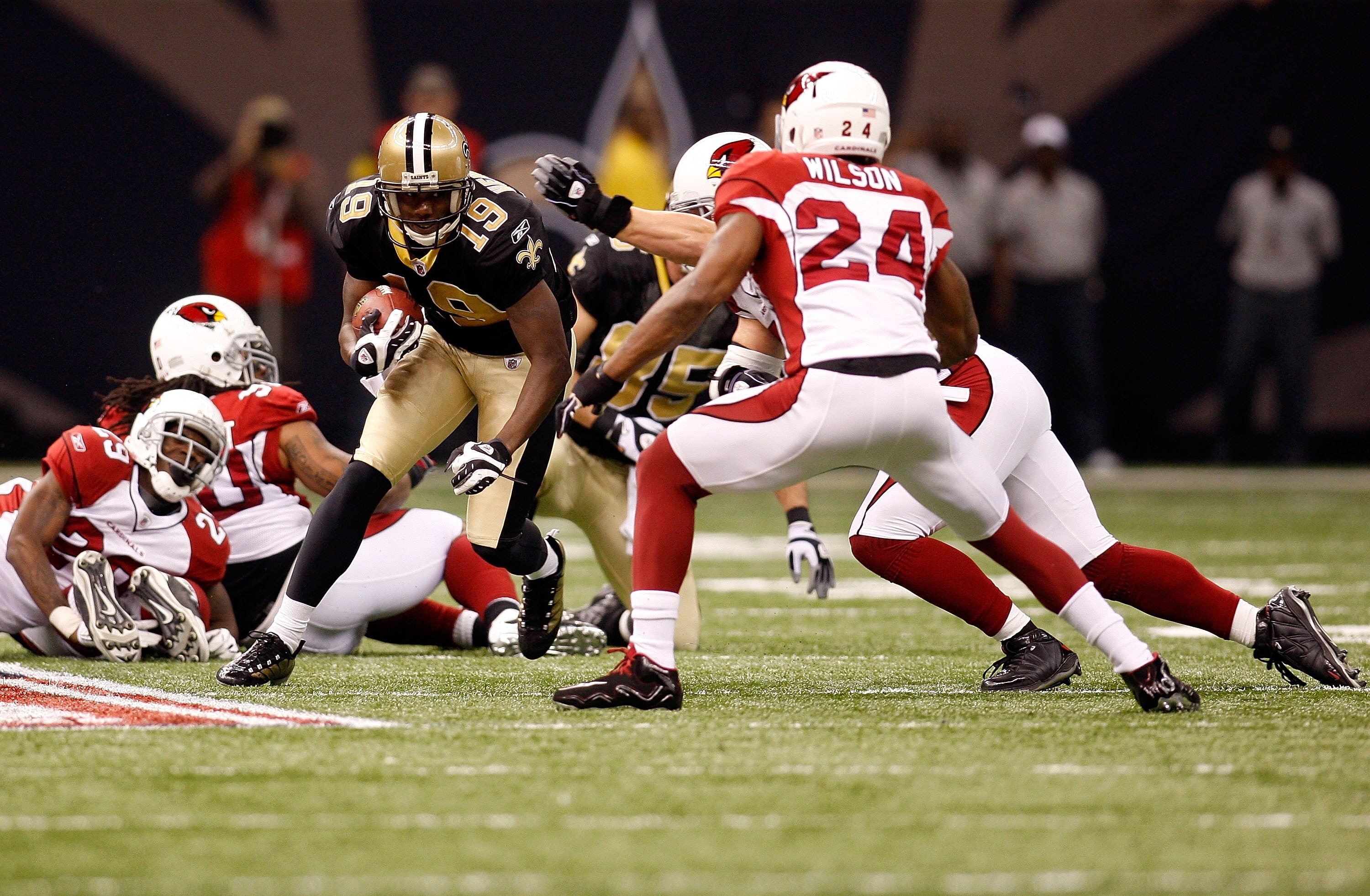 NEW ORLEANS - JANUARY 16:  Devery Henderson #19 of the New Orleans Saints runs for yards after the catch against Adrian Wilson #24 of the Arizona Cardinals during the NFC Divisional Playoff Game at Louisana Superdome on January 16, 2010 in New Orleans, Lo