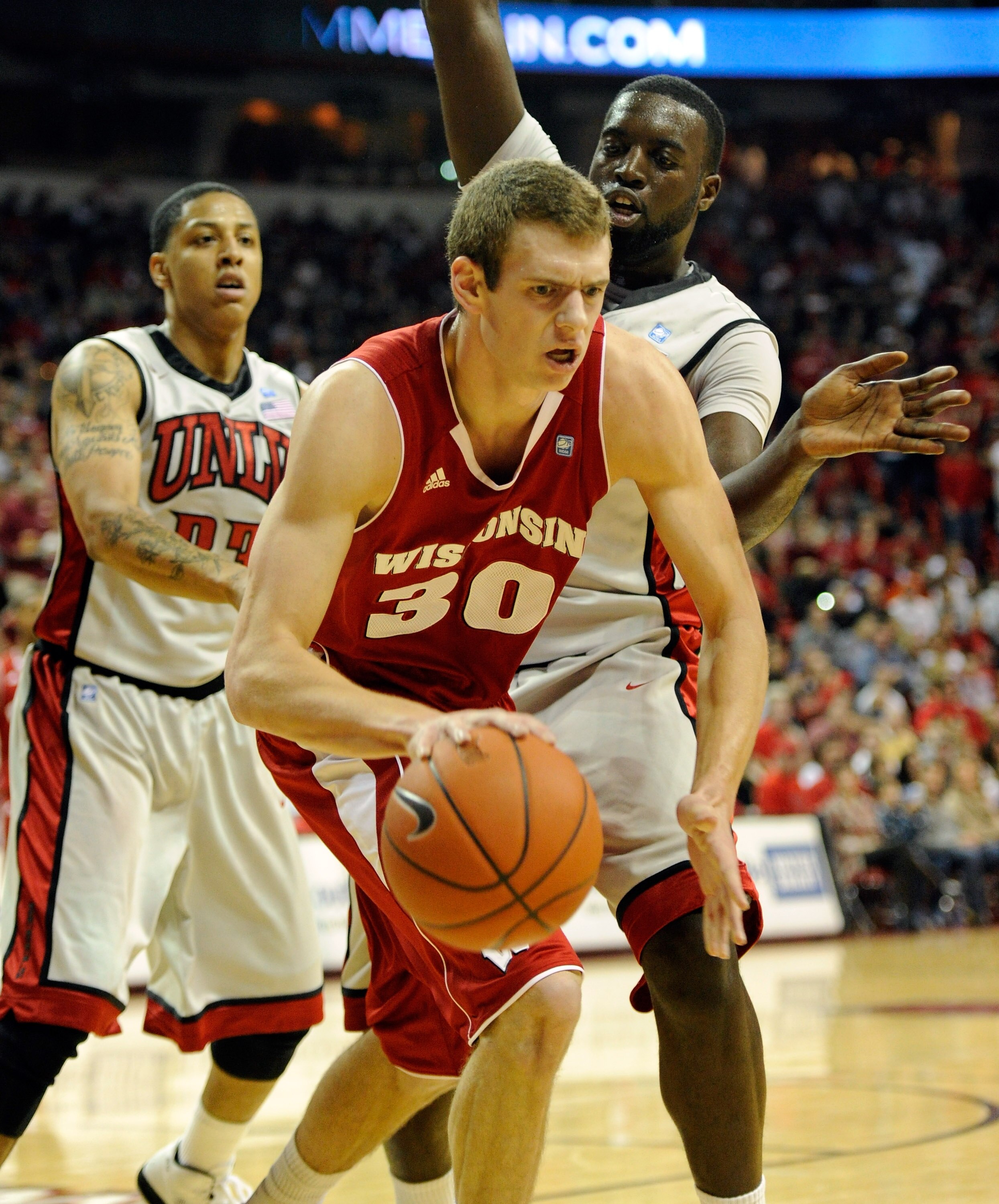 LAS VEGAS - NOVEMBER 20:  Jon Leuer #30 of the Wisconsin Badgers tries to get away from defenders Tre'Von Willis (L) #33 and Brice Massamba #12 of the UNLV Rebels during their game at the Thomas & Mack Center November 20, 2010 in Las Vegas, Nevada. UNLV w