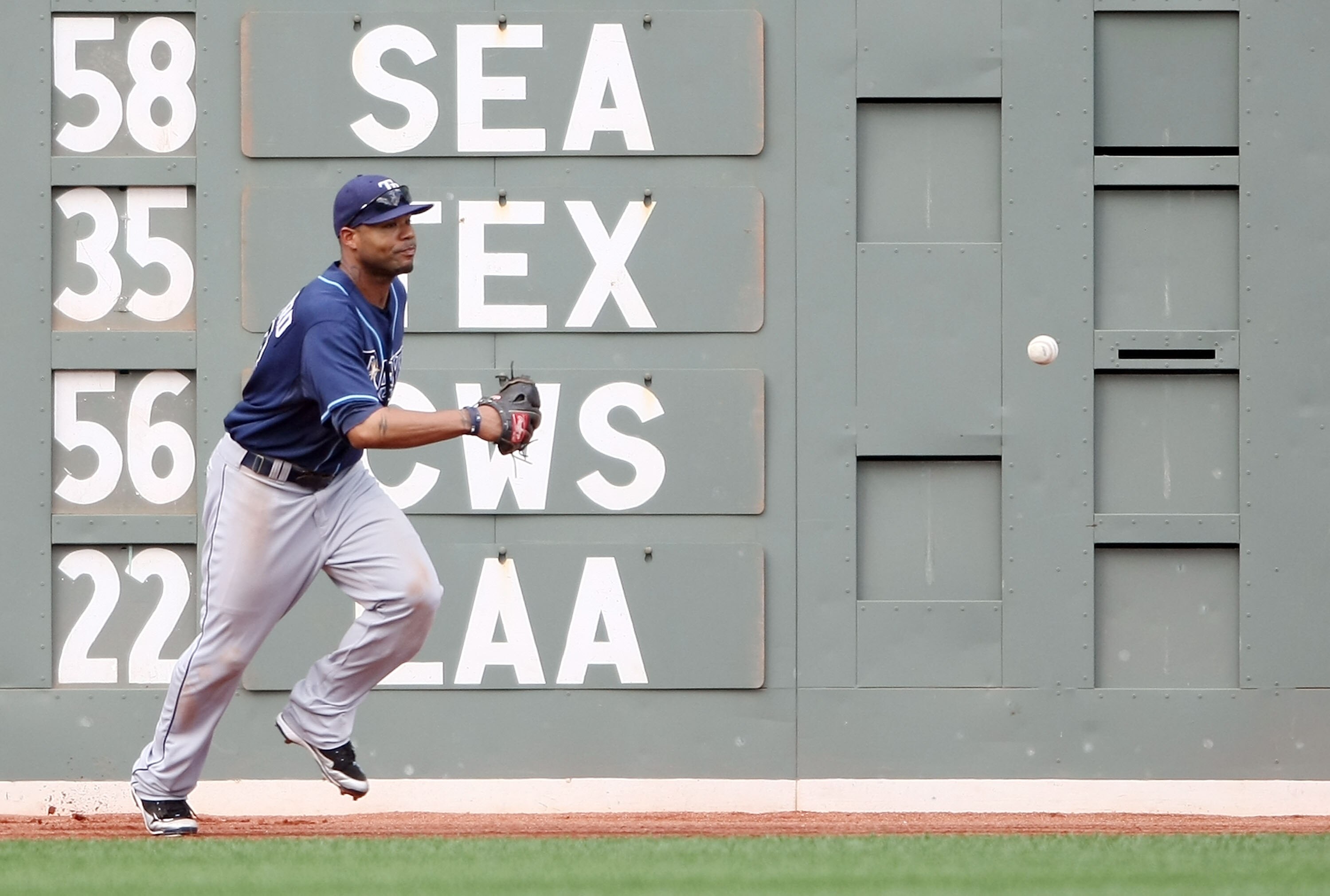 BOSTON - SEPTEMBER 13:  Carl Crawford #13 of the Tampa Bay Rays misses a hit by Victor Martinez of the Boston Red Sox on September 13, 2009 at Fenway Park in Boston, Massachusetts. The Red Sox defeated the Rays 3-1.  (Photo by Elsa/Getty Images)