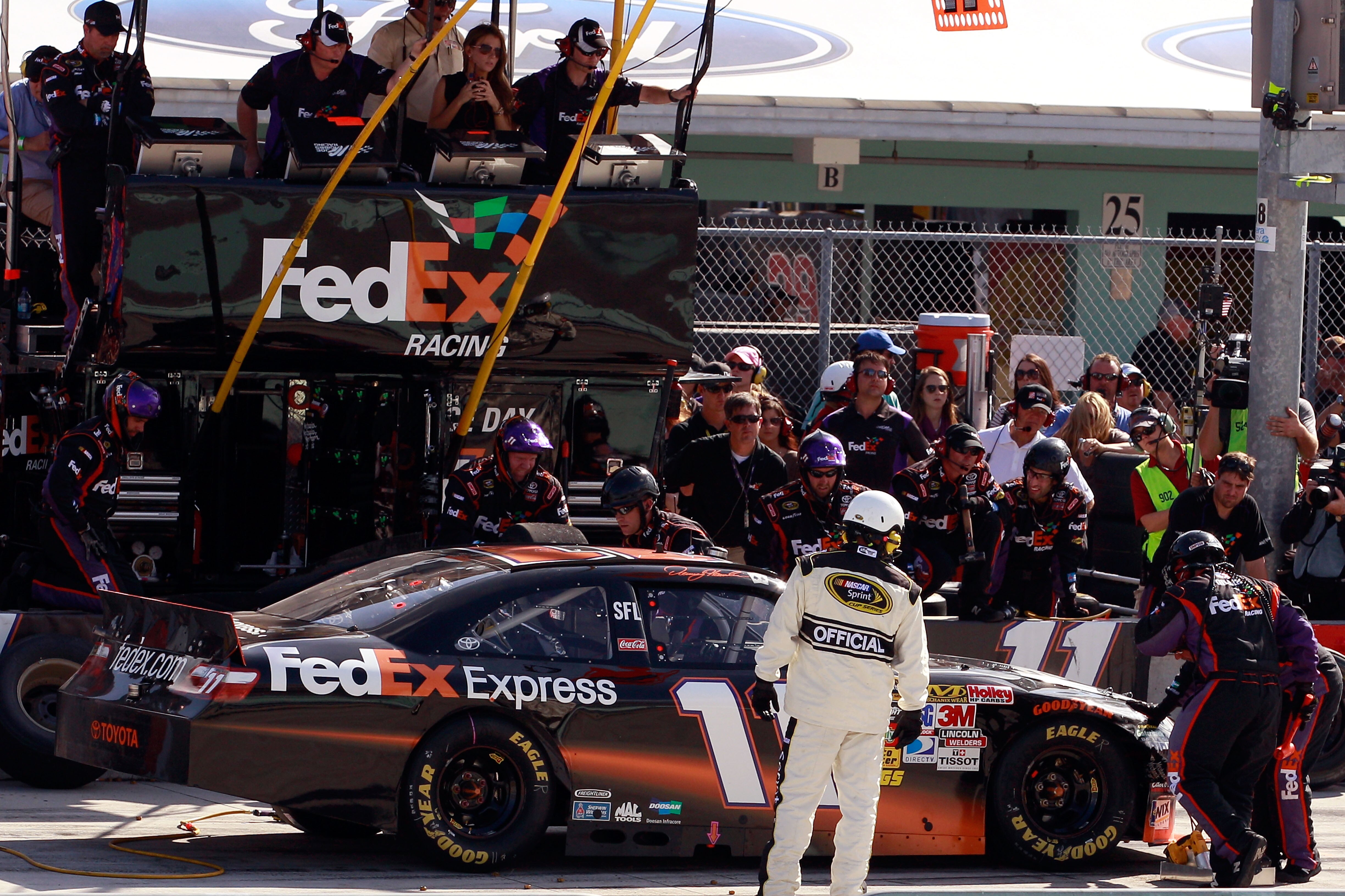 HOMESTEAD, FL - NOVEMBER 21:  Denny Hamlin, driver of the #11 FedEx Toyota, makes a pit stop after sustaining front end damage during the NASCAR Sprint Cup Series Ford 400 at Homestead-Miami Speedway on November 21, 2010 in Homestead, Florida.  (Photo by