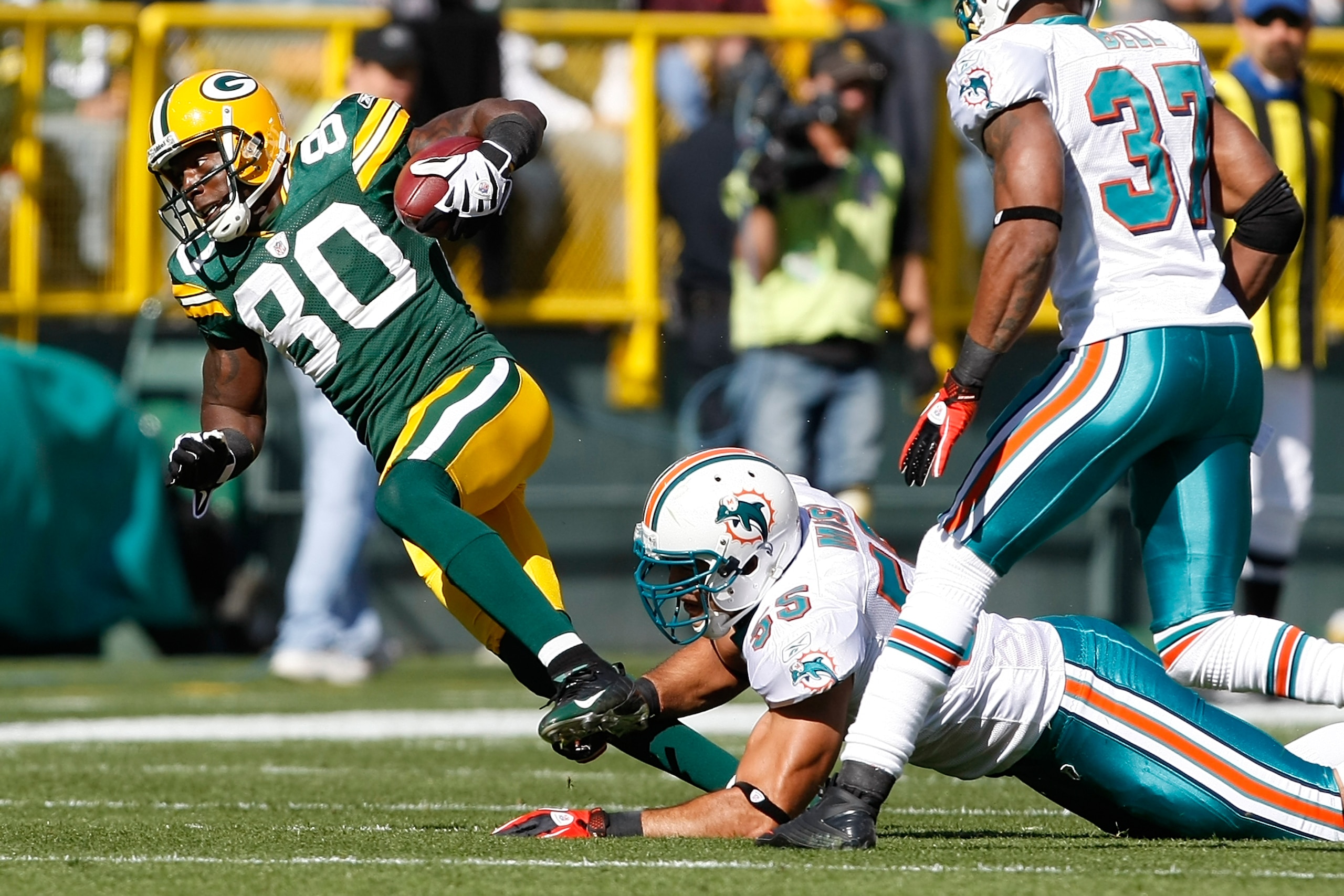 GREEN BAY, WI - OCTOBER 17: Donald Driver #80 of the Green Bay Packers is tripped as he runs against the Miami Dolphins at Lambeau Field on October 17, 2010 in Green Bay, Wisconsin. (Photo by Scott Boehm/Getty Images)